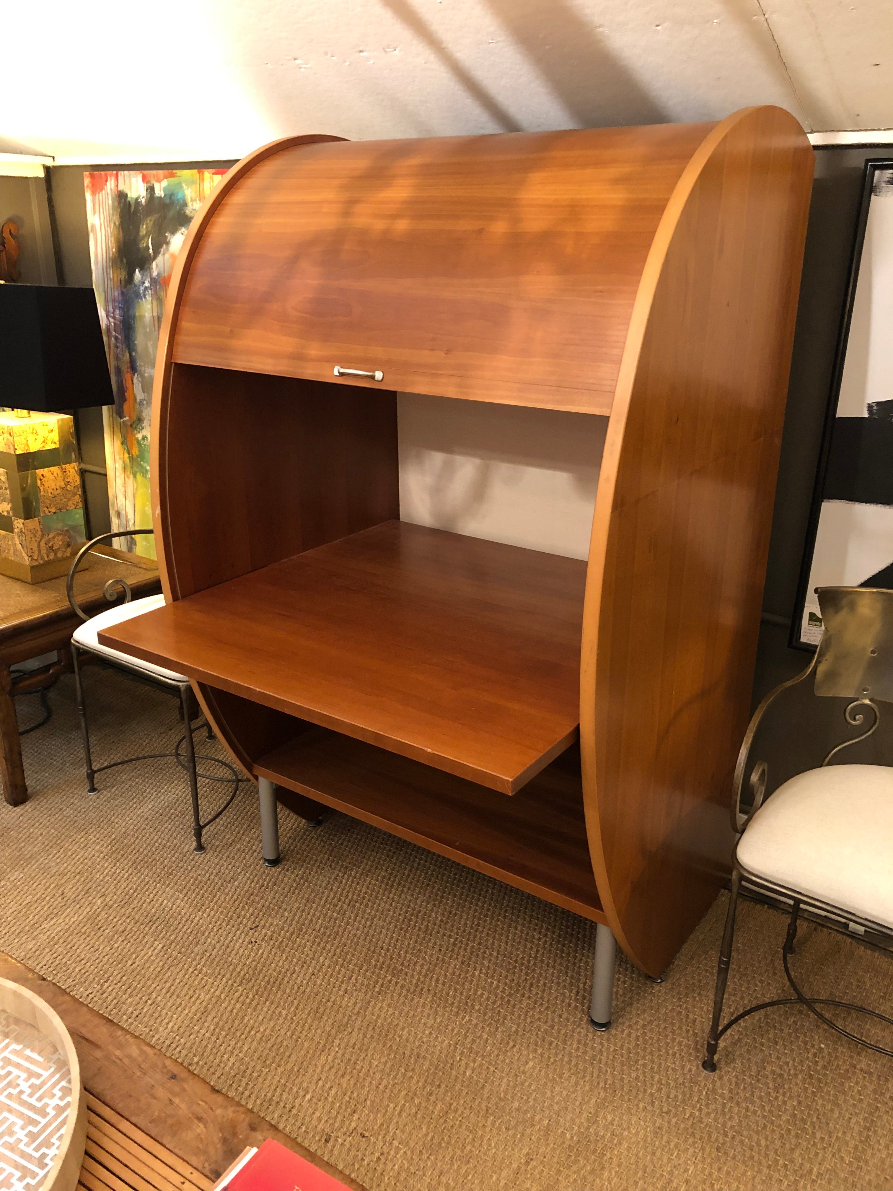 A rare sculptural Mid-Century Modern cherry tambour front sensually rounded dry bar or desk having a front that slides up and down to reveal a pull out table top. Incredible design and clever engineering. There is also a bottom shelf. Makes an