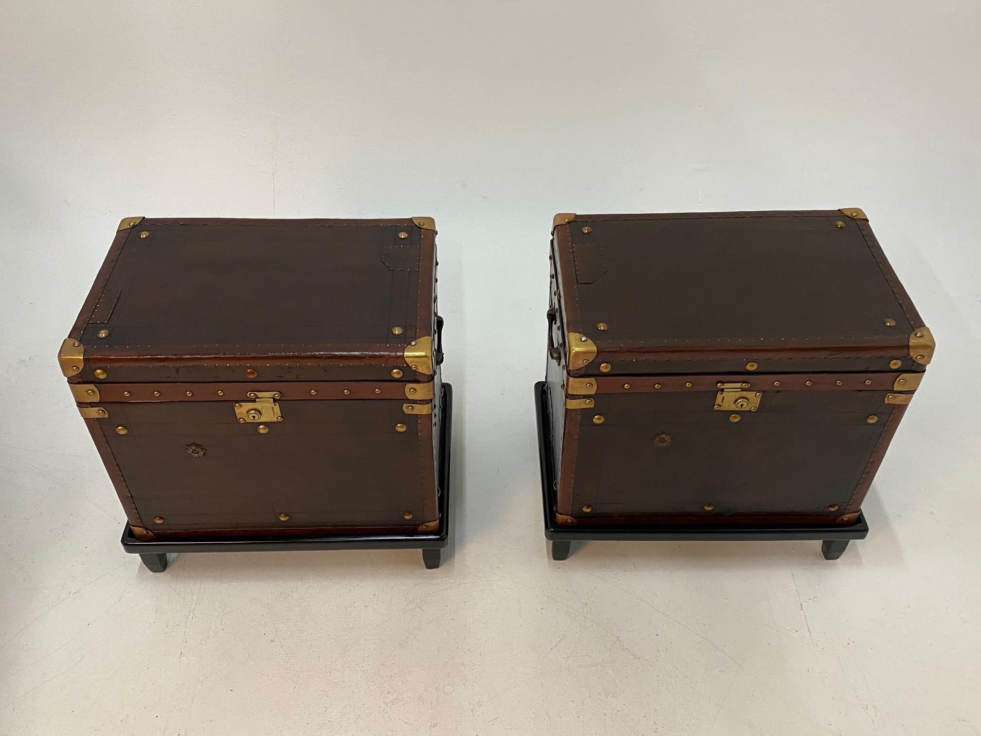 Superb pair of early 20th century leather bound military trunks with handsome brass mounts, studs and hardware and dark blue fabric lined interiors. Each rests on a custom stand so perfect for end tables or night stands.
Measurement of trunks only: