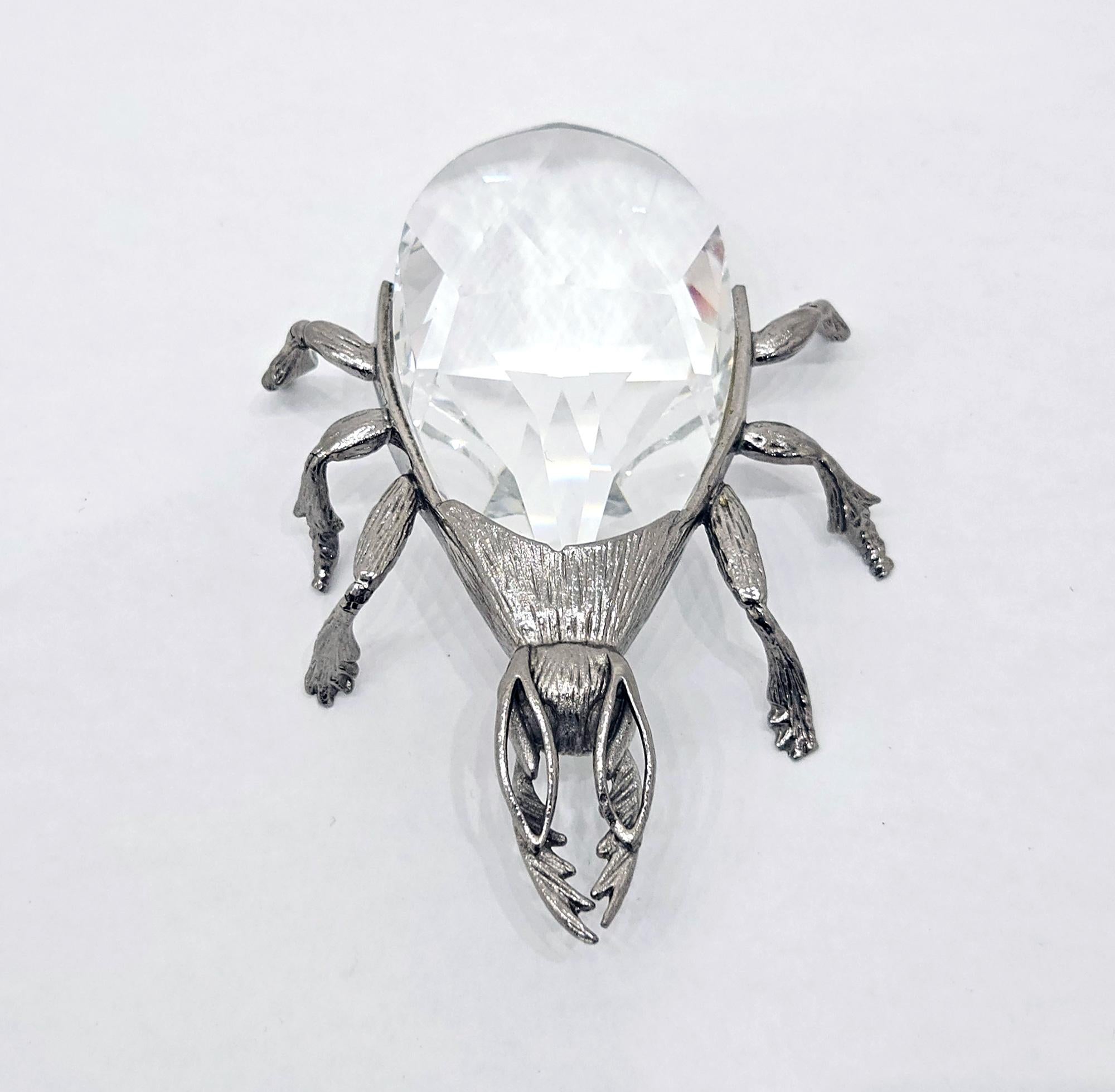An eccentric and unusual novelty vintage bottle opener in the shape of a beetle, made by Swarovski in c. 1978.

The body of the beetle is well defined with a great presence. It is rhodium plated, and is the ‘smooth’ type (a similar model with a
