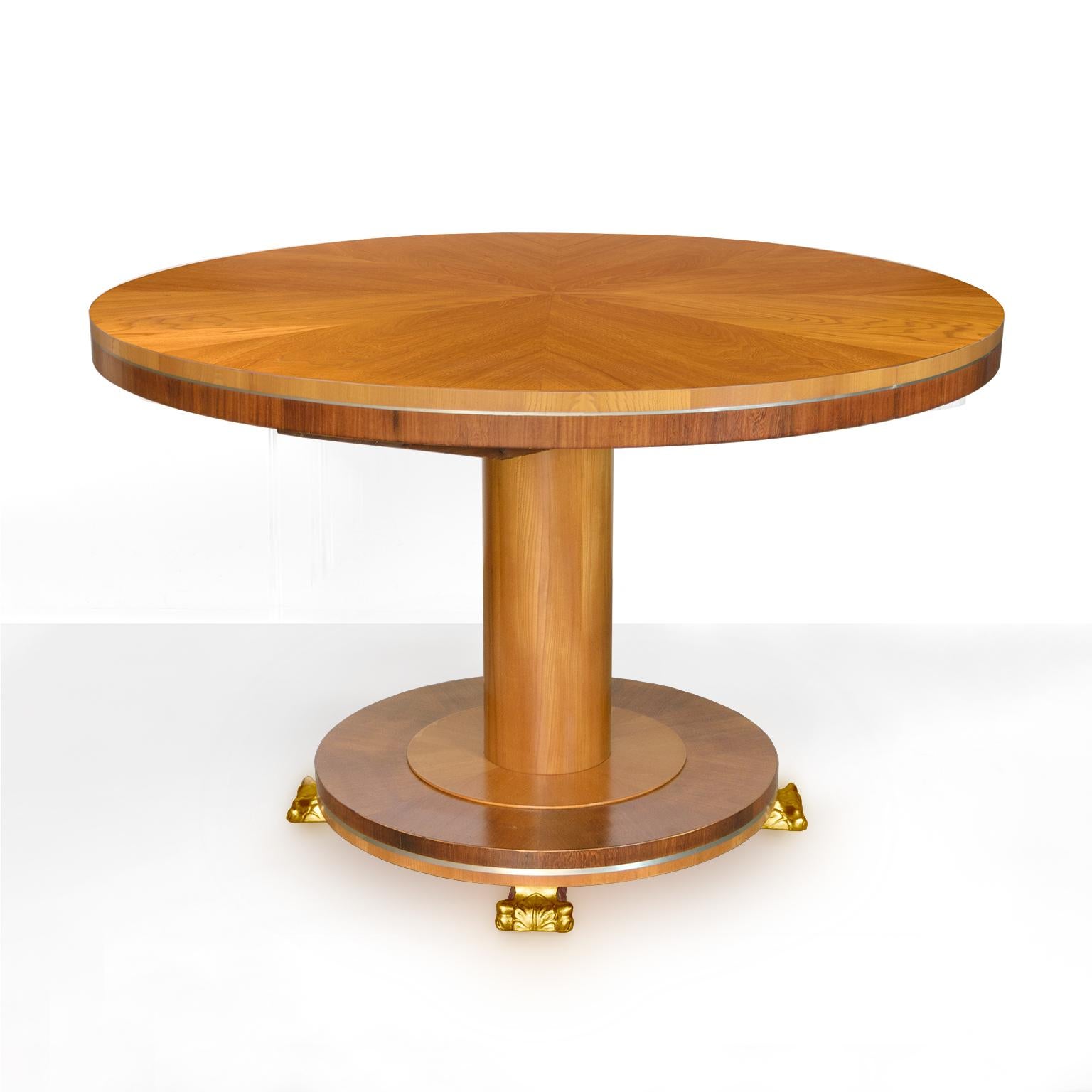 Rare Swedish Art Deco dining table (has 4 matching chairs sold separately) by architect Carl Bergsten. Masterfully crafted table is veneered in elm, mahogany and detailed with pewter inlay and carved gilt-wood feet. Table expands but has no leaves.