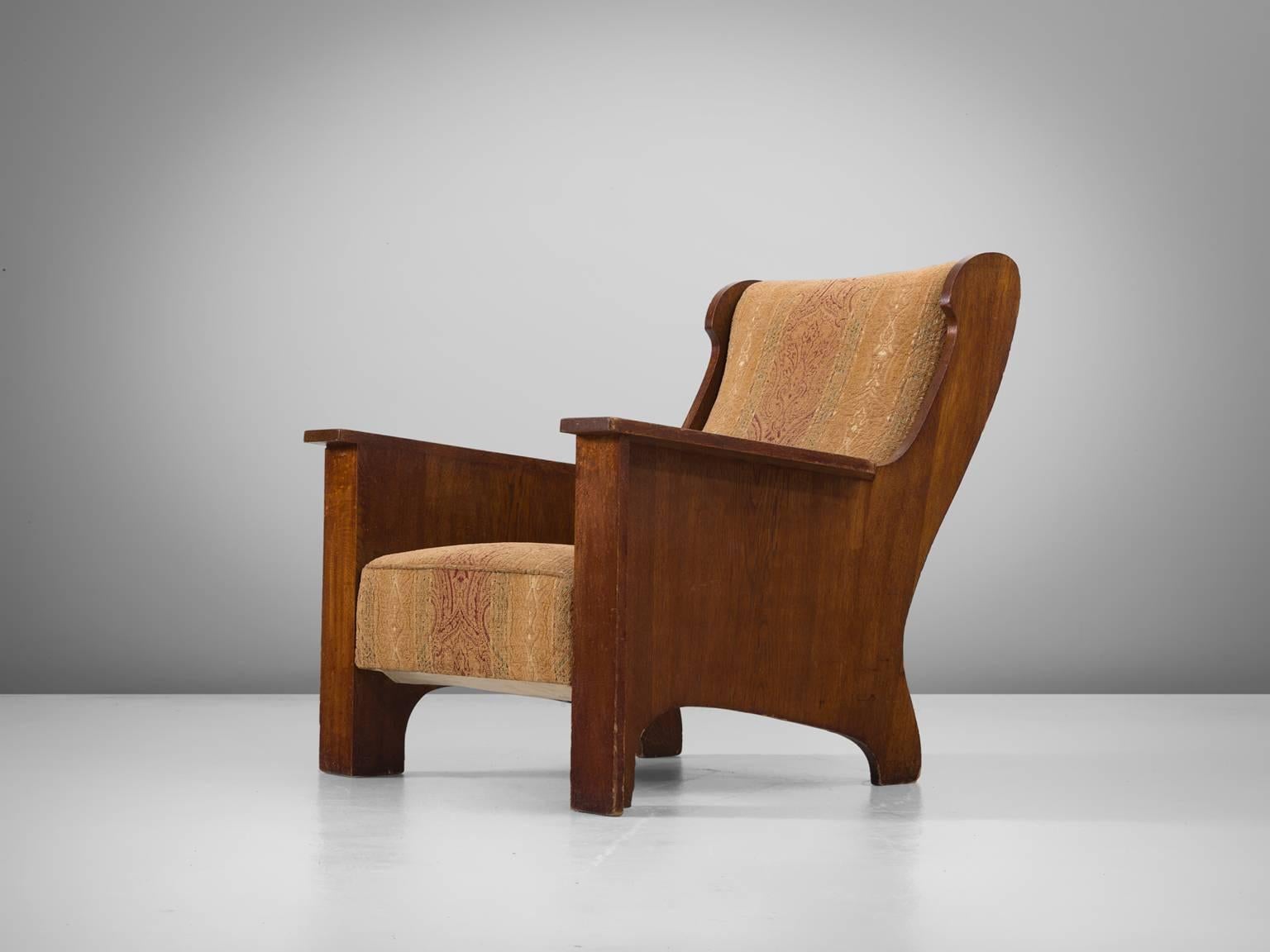 Armchair, in oak and fabric, Sweden 1930s. 

Extraordinary and wide Art Deco lounge chair with a nicely patinated oak wooden frame. This chair shows some interesting lines. The back is nicely curved with elegant lines. The front has a more sturdy