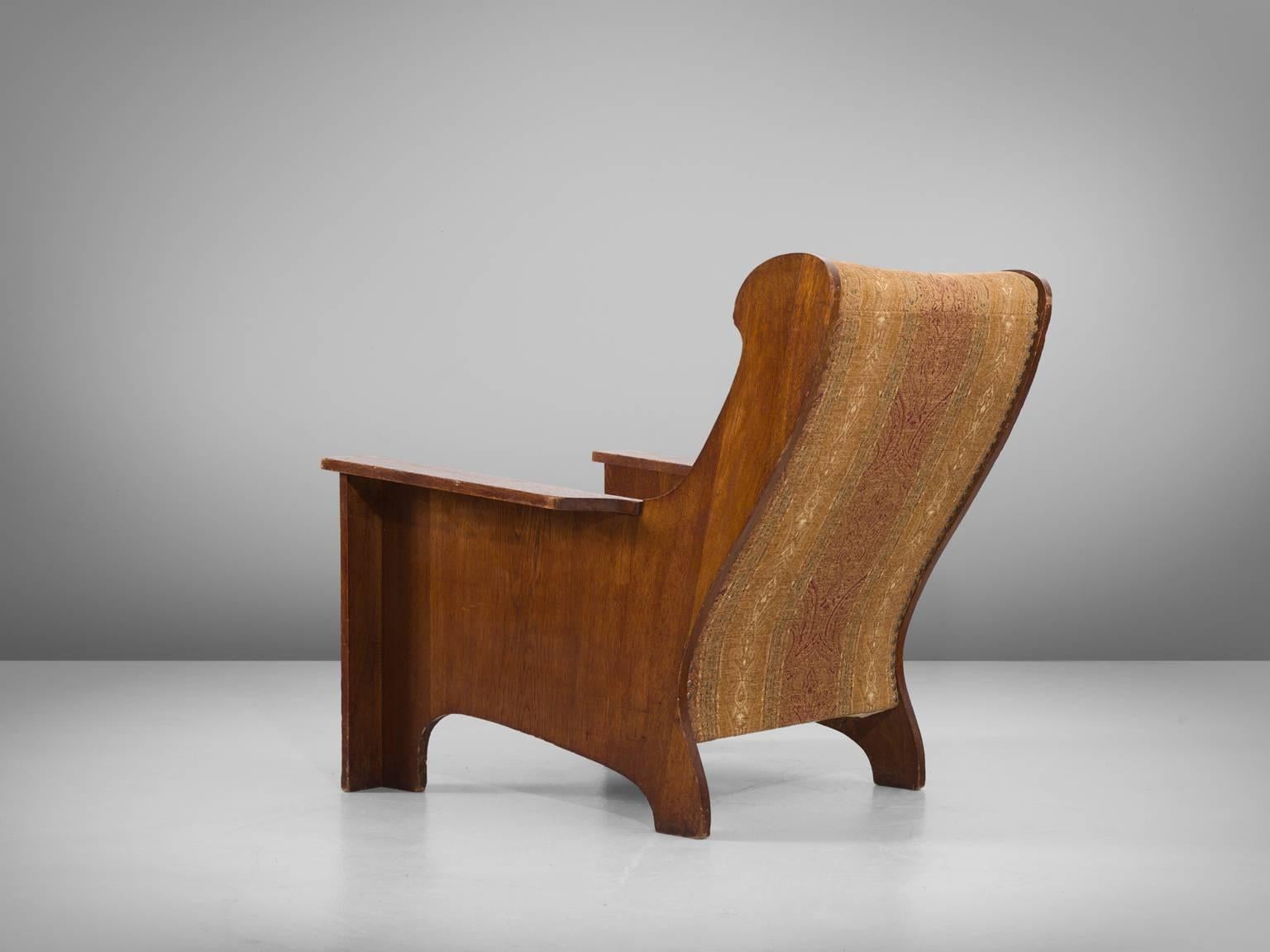 Armchair in oak and fabric, Sweden, 1930s. 

Extraordinary and wide Art Deco lounge chair with a nicely patinated oak wooden frame. This chair shows some interesting lines. The back is nicely curved with elegant lines. The front has a more sturdy