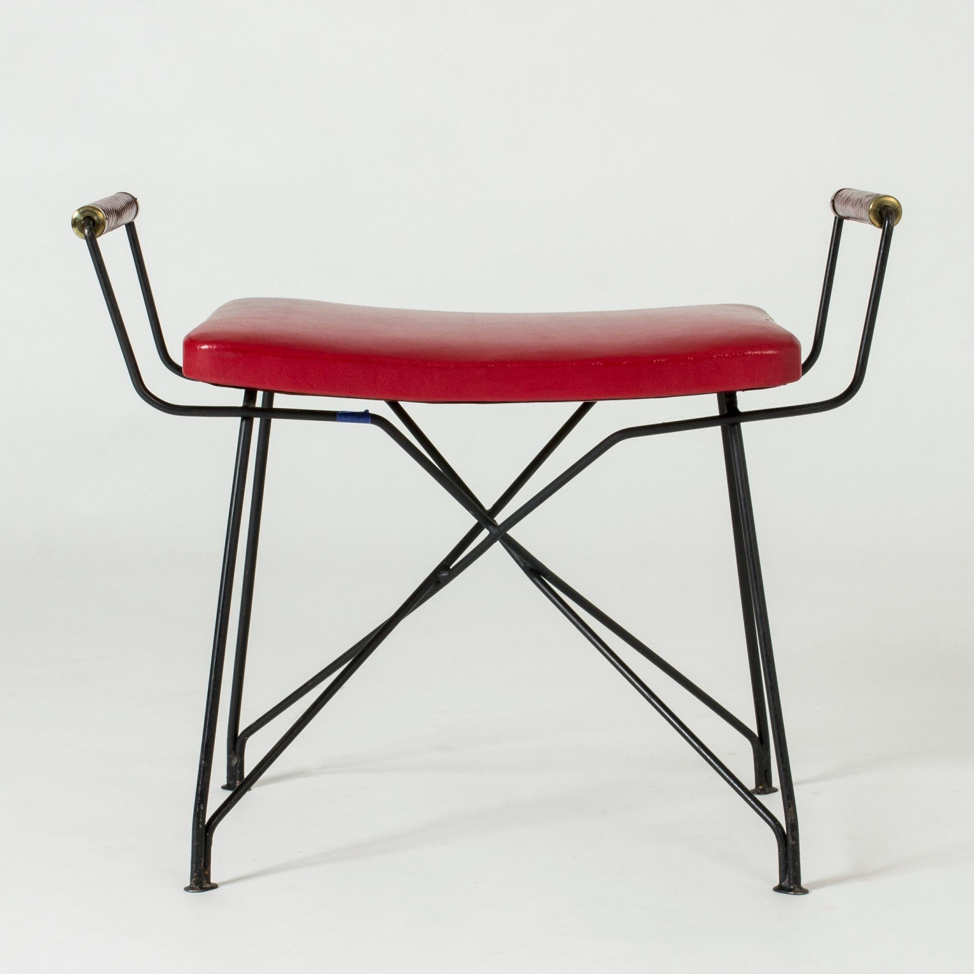 Rare leather and lacquered metal stool by Hans-Agne Jakobsson, made in his first studio in Åhus in the early 1950s. The elegant wreathed handles and the graphic lines of the legs make an enticing combination. The leather is original.