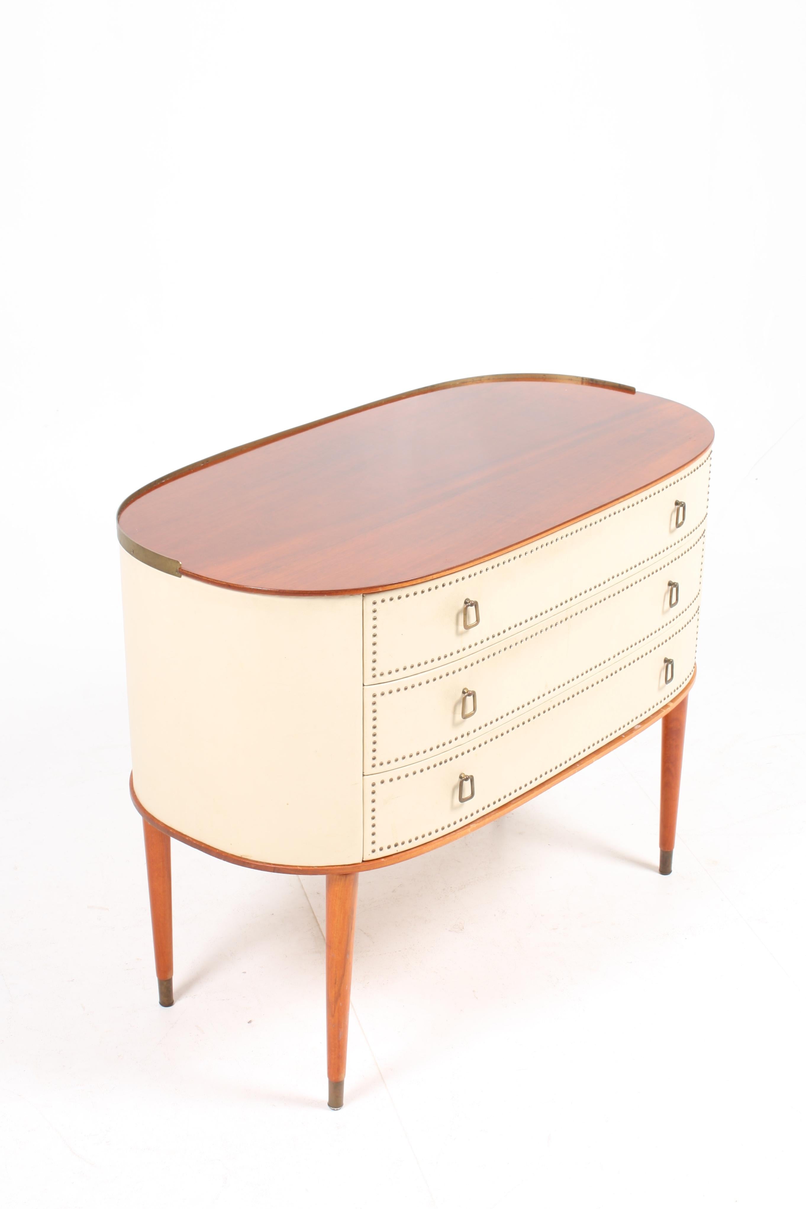 Oval commode in mahogany and vinyl with hardware in brass. Designed by Halvdan Petterson for Tibro Møbelfabrik in the 1940s. Great original condition.