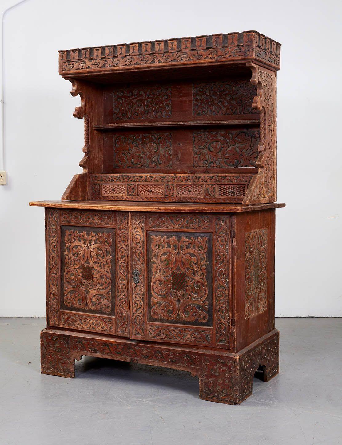 A very rare early 17th century Swiss flachesgurtwerk manorial court cupboard having overhanging dentil carved canopy with carved underside on gothic flanges and baroque columns over shelves and spice drawers above lower cupboard with two doors,