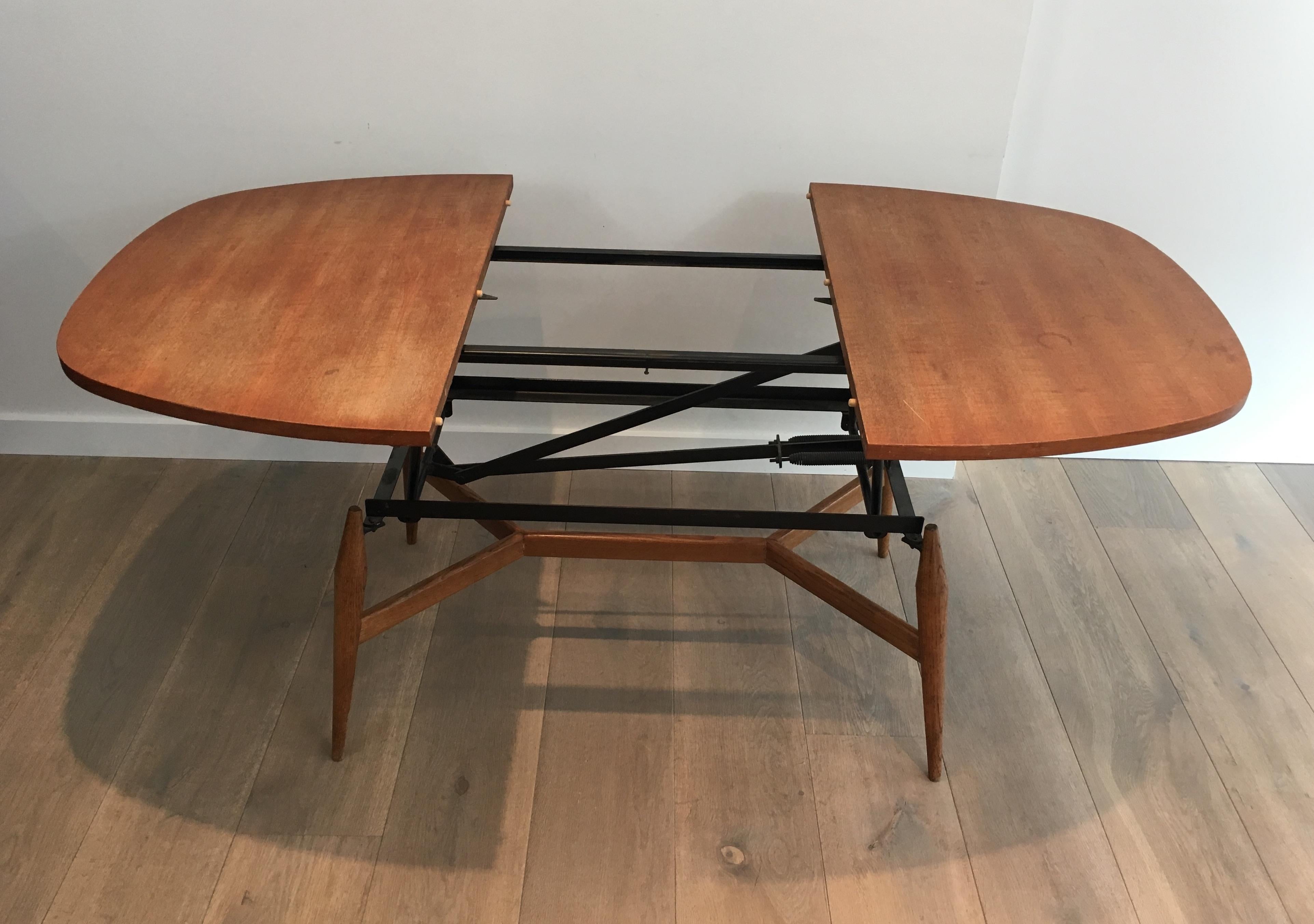 Rare system coffee table that can be changed into a 6 persons dinning table. There is a system to open the coffee table in two, having it going up an adding a wooden extension to change it into a dinning table. French, circa 1950.