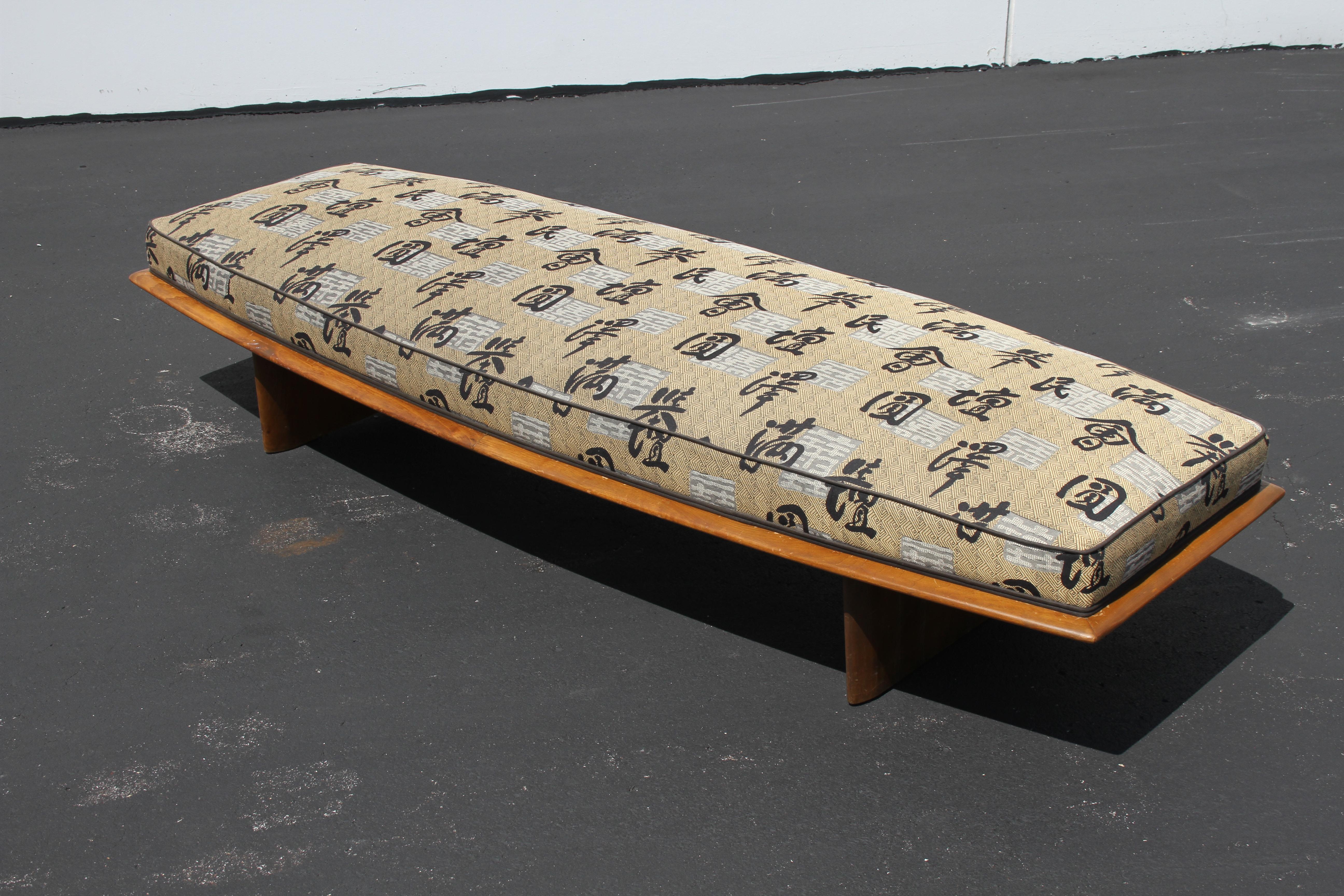 Rare T. H. Robsjohn-Gibbings for Widdicomb daybed, boat shaped upholstered form on plinth tapered legs and tapered wood surround. Shown in original finish with older reupholstery. Price includes wood frame refinishing prior to shipping, custom stain