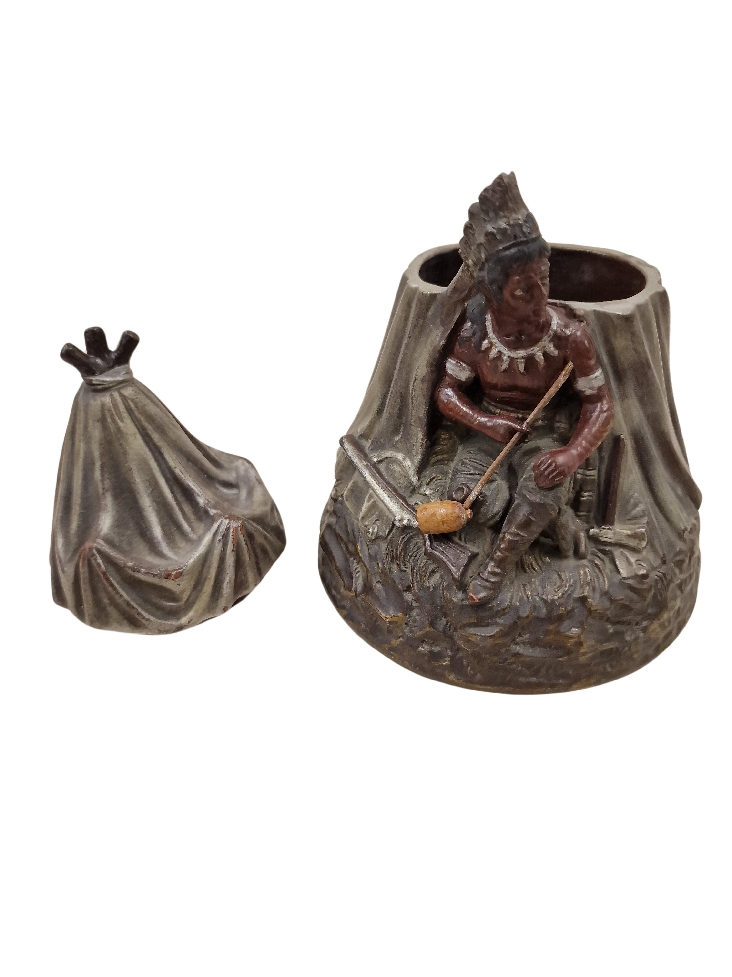 Early, very rare tobacco box with a very unusual scene from the famous ceramic Manufactory in Utrecht in the Netherlands, made around 1890. 

This depiction is extraordinary - a native American sits in front of his tent and smokes a peace pipe