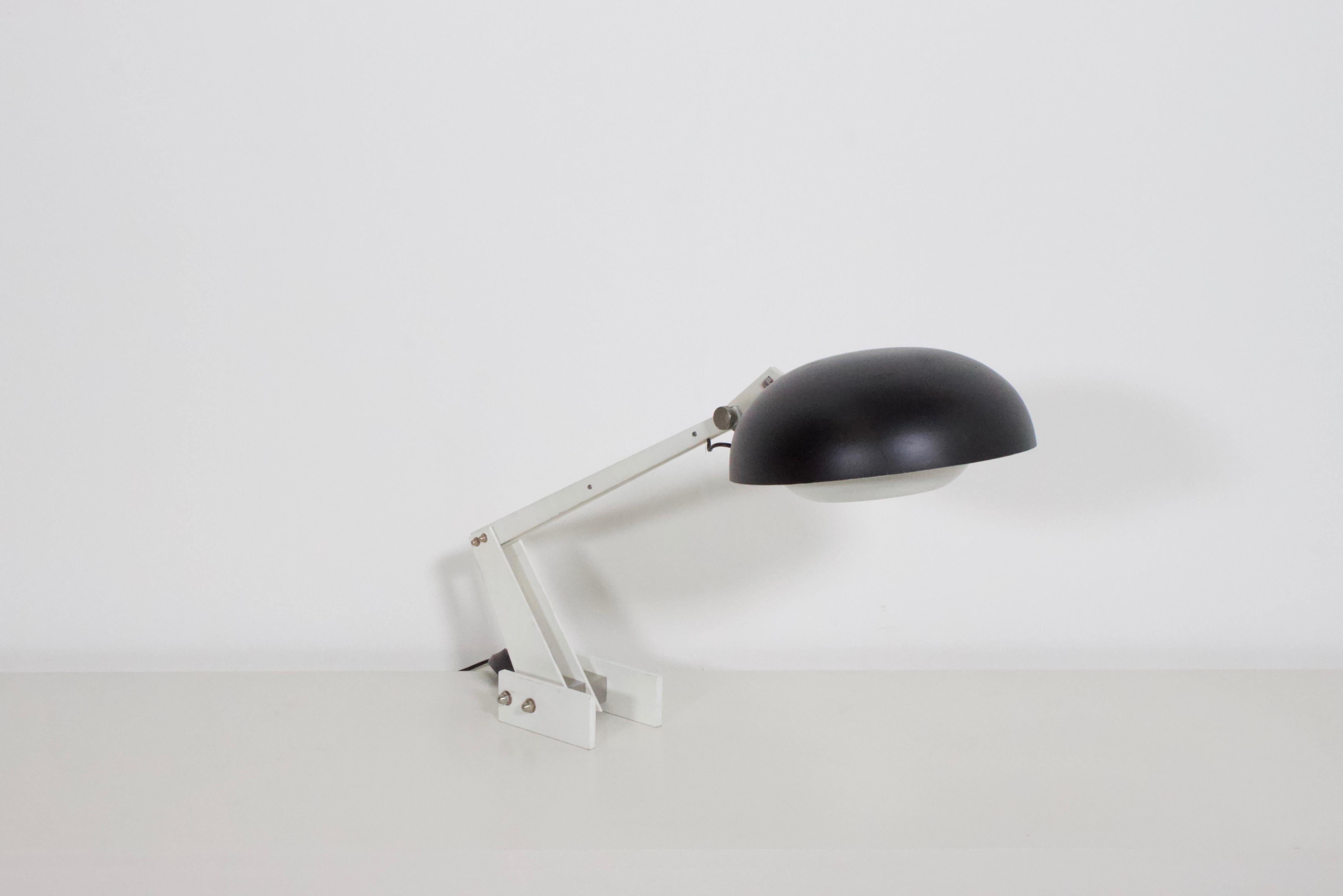 Very rare industrial table / desk lamp by Wim Rietveld in good condition.

Manufactured by Gispen in the Netherlands.

Black aluminum shade with a white aluminum diffuser which is adjustable.

Heavy enameled steel frame bolted together with