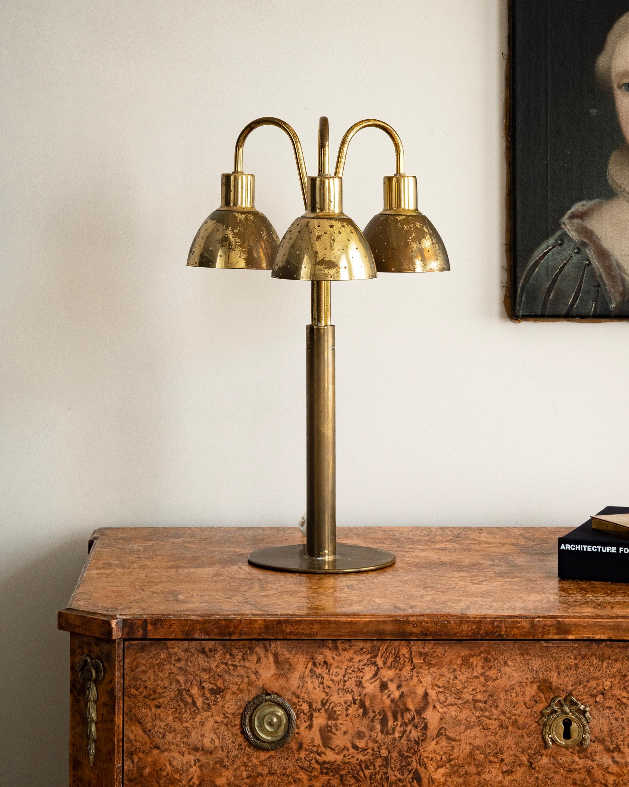 Rare mid 20th century modern brass three light table lamp by Hans-Agne Jacobsson (Sweden, 1919-2009) with perforated shades, model B211 for Markaryd Sweden. Ca 1950. 