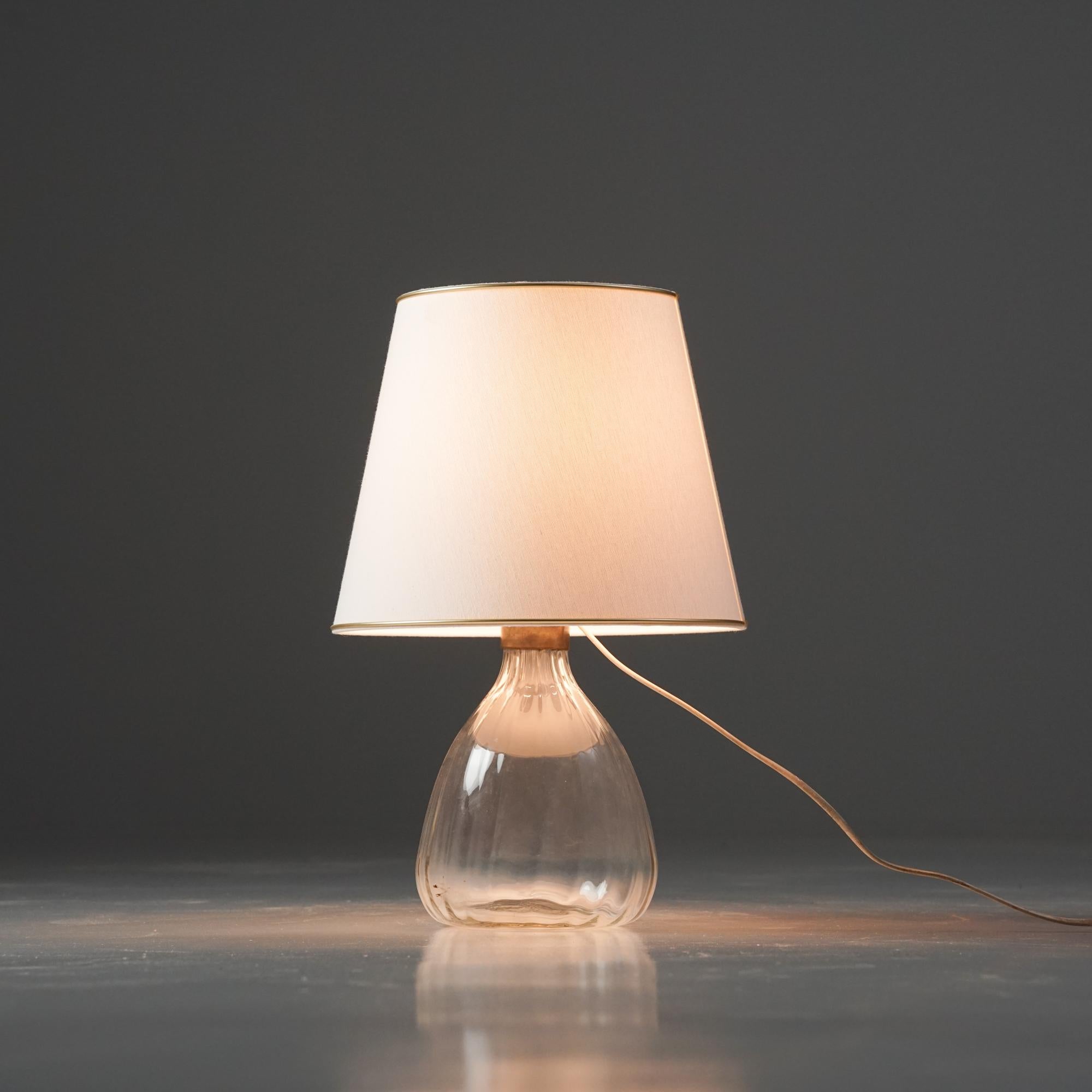 Rara lámpara de mesa, diseñada por Gunnel Nyman, década de 1940. Marco de cristal con pantalla de tela nueva. Buen estado vintage, pátina menor acorde con la edad y el uso. 

Gunnel Nyman es uno de los diseñadores de vidrio finlandeses más