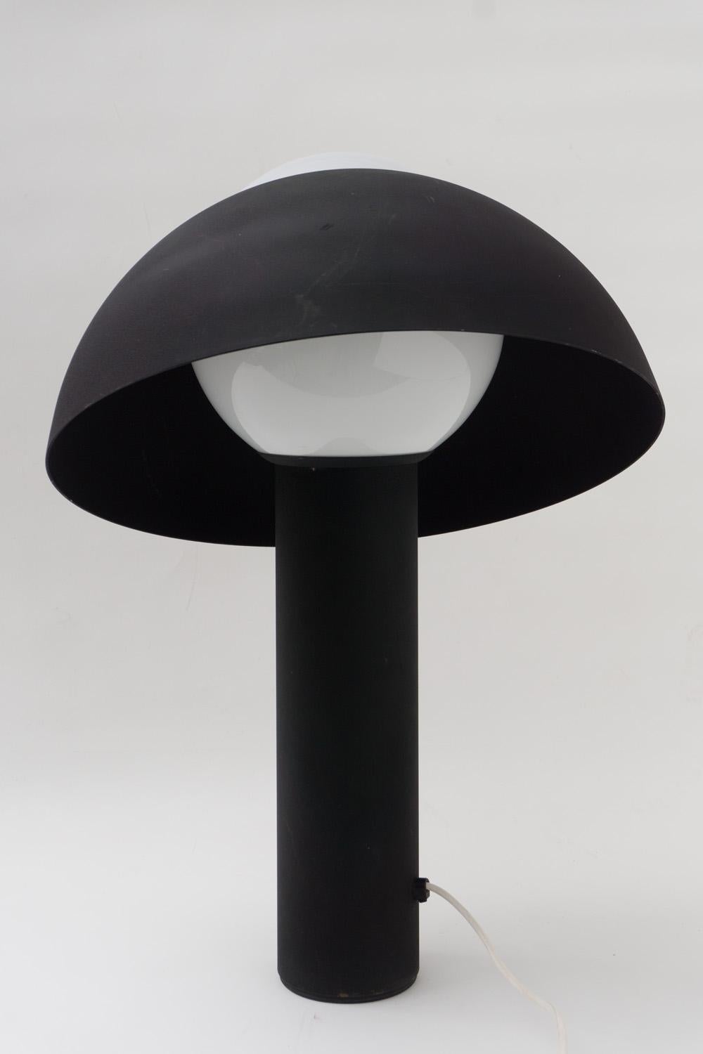 Cette lampe de table en métal est une pièce d'éclairage extraordinaire. Il a une qualité solide et ludique, grâce à son abat-jour amovible et réglable en position. Coates en laque structurelle noir mat, lampe ronde en verre satiné. 

Modèle 