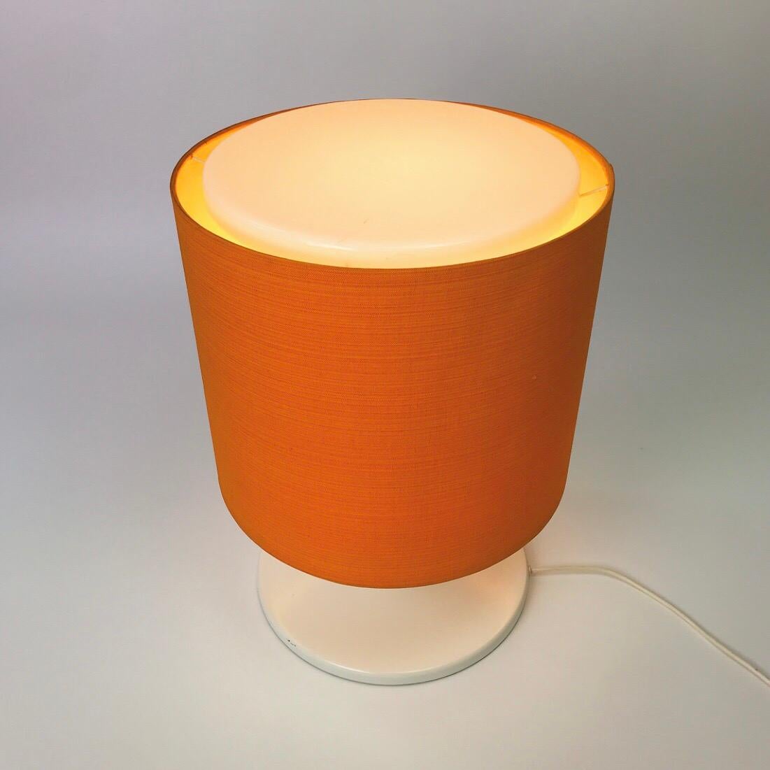 A real eyecatcher is this beautiful piece made in the 1970s by Staff Leuchten, Germany.

The tulip white lacquered base, the orange fabric and top to it all the milky white perspex top .... it’s just a stunning piece of design. 

Staff Leuchten