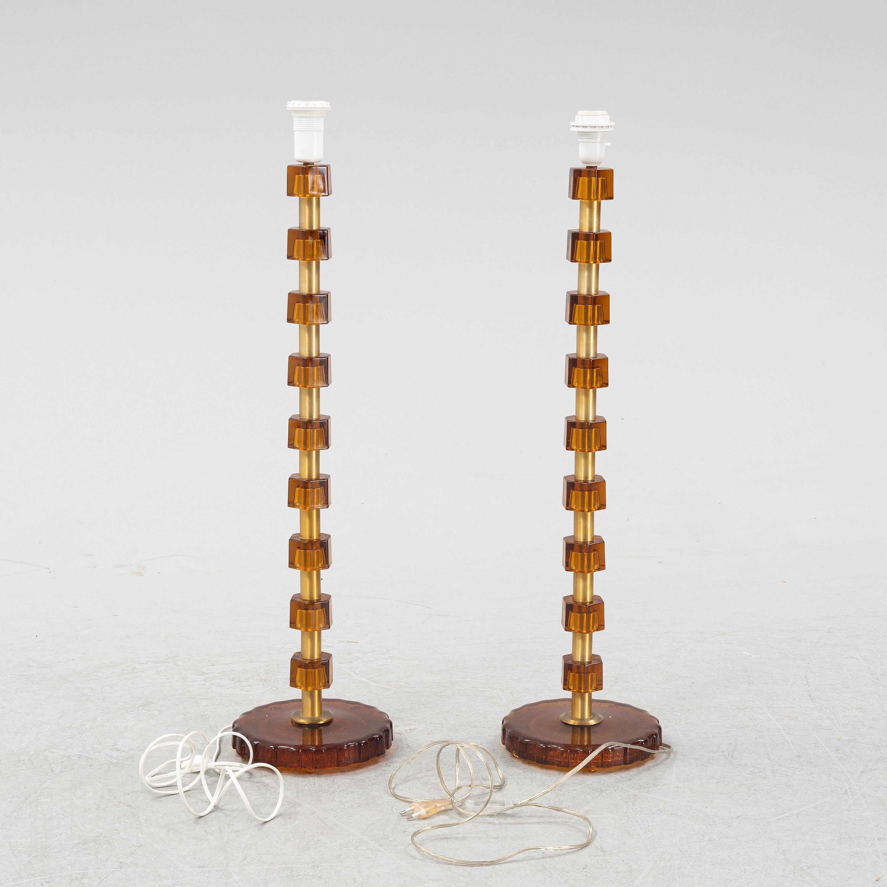 Rare of tall pair of lamps from Sweden 1960s cast glass amber color and brass. Manufactured in Sweden 1960 by Nybro Armaturfabrik Signed Anf 59
Good condition

