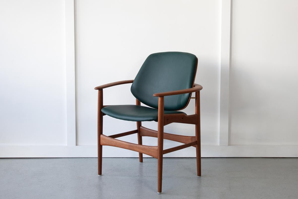 A rare Danish armchair, designed by Arne Hovmand-Olsen and produced by Onsild Møbelfabrik for Jutex, Århus in the 1950's. The frame is sculpted in solid teak with the armrest wrapping around the back of the chair. The perfectly angled backrest is