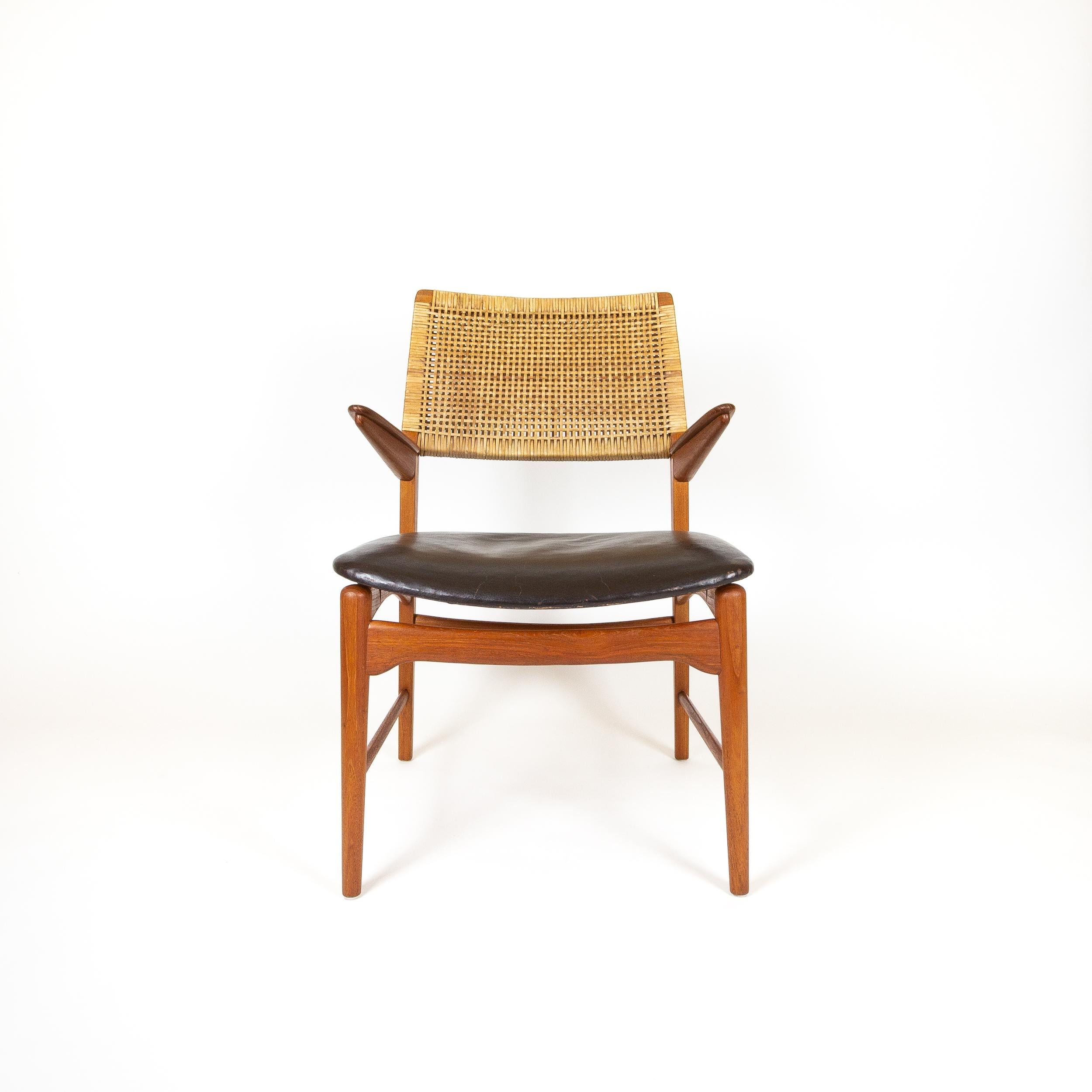 A very rare teak, leather and cane Model 48 Armchair designed by E. Knudsen for Jensen & Lykkegaard cabinetmakers, Odense, Denmark, 1950s. This a real collector's piece. The short torpedo arms and big, wide leather seat pad create a startling