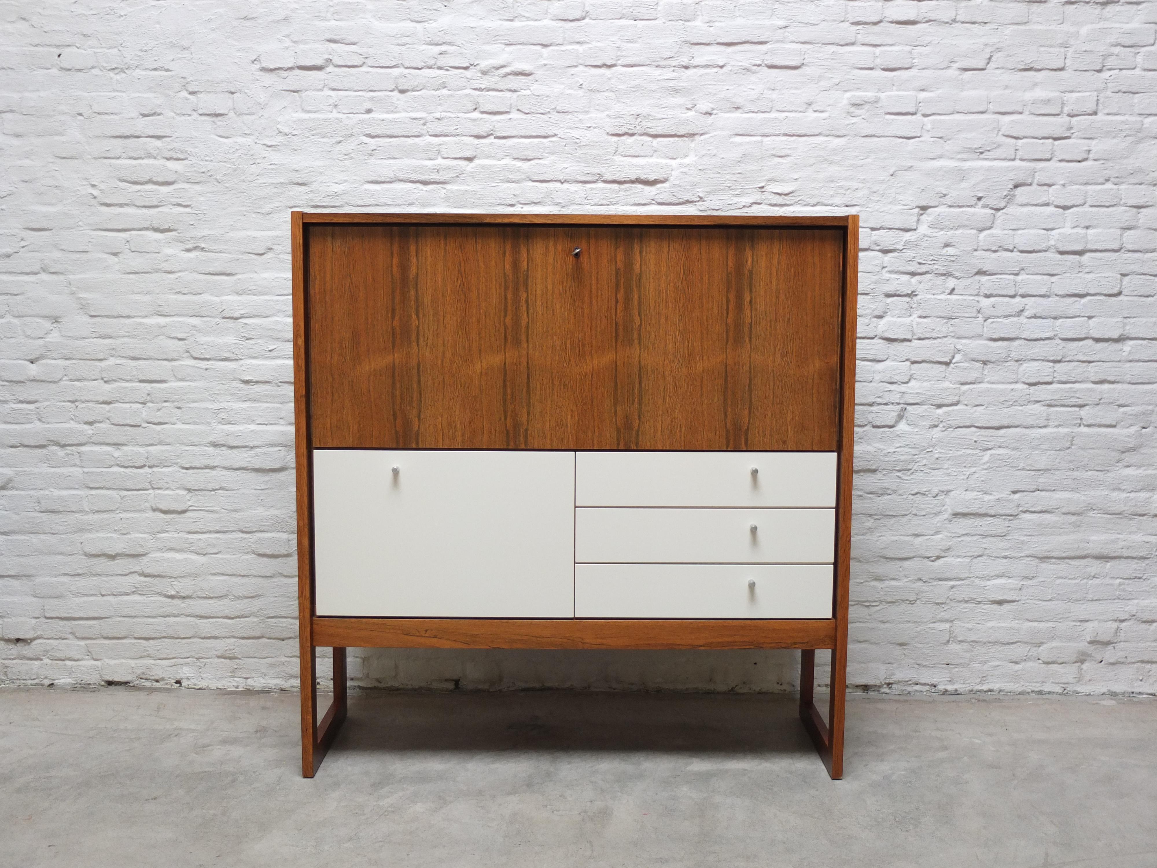 Bellissimo mobile da segreteria prodotto da V-Form in Belgio intorno al 1965. Una bella venatura del legno con un accento bianco molto decorativo sul pannello inferiore dell'anta e sui tre cassetti che aggiunge un tocco di leggerezza moderna a