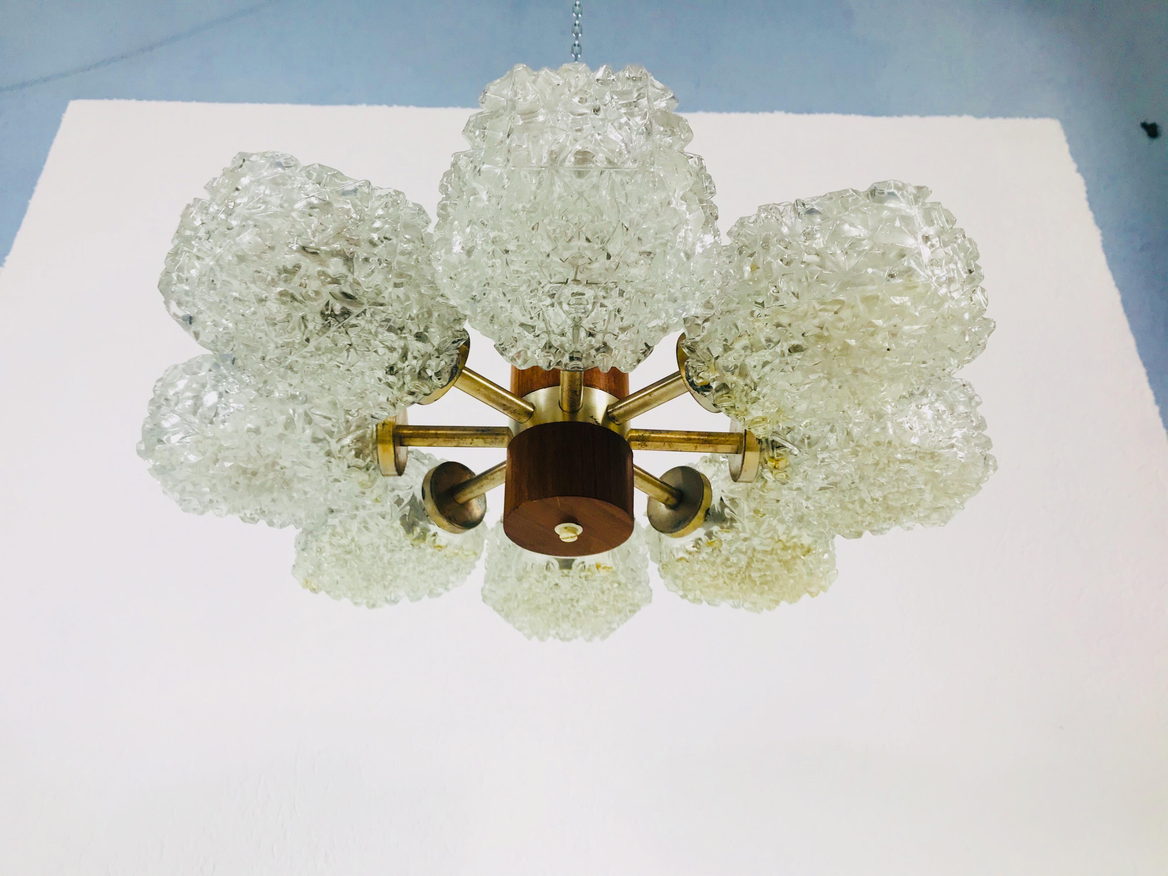 Temde teak and brass adjustable flush mount made in the 1960s. It is fascinating with its rare glass shapes which are adjustable. The eight arms are all made of polished brass.

Measurements:

Height: 18 cm

Diameter: 50 cm 

The light