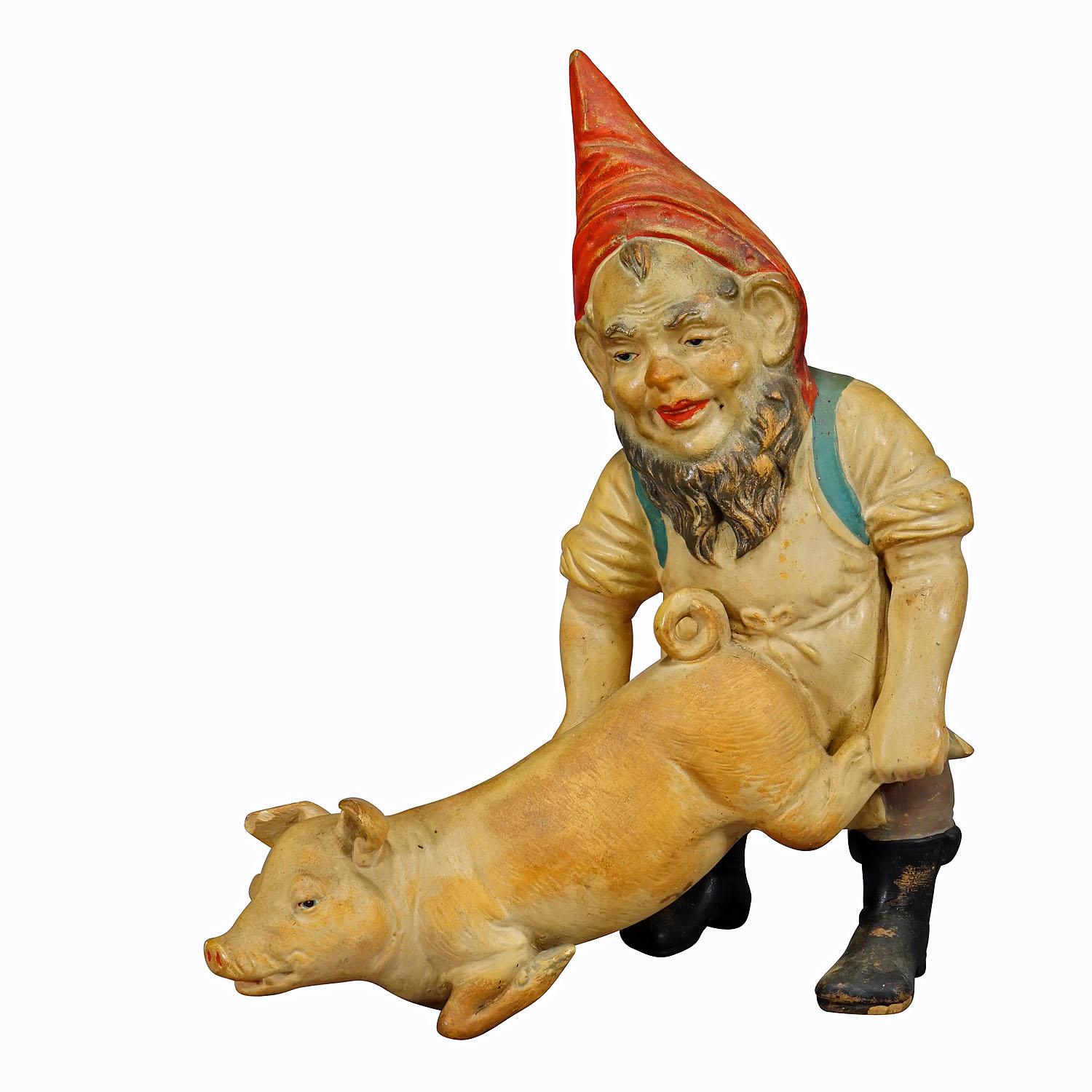 Rare Terracotta Garden Gnome with Pig, Germany ca. 1920s

A large garden gnome manufactured by Heissner, Germany, ca. 1920s. The dwarf has grabbed a pig by the hind legs and is holding it like a wheelbarrow. Very good original vintage