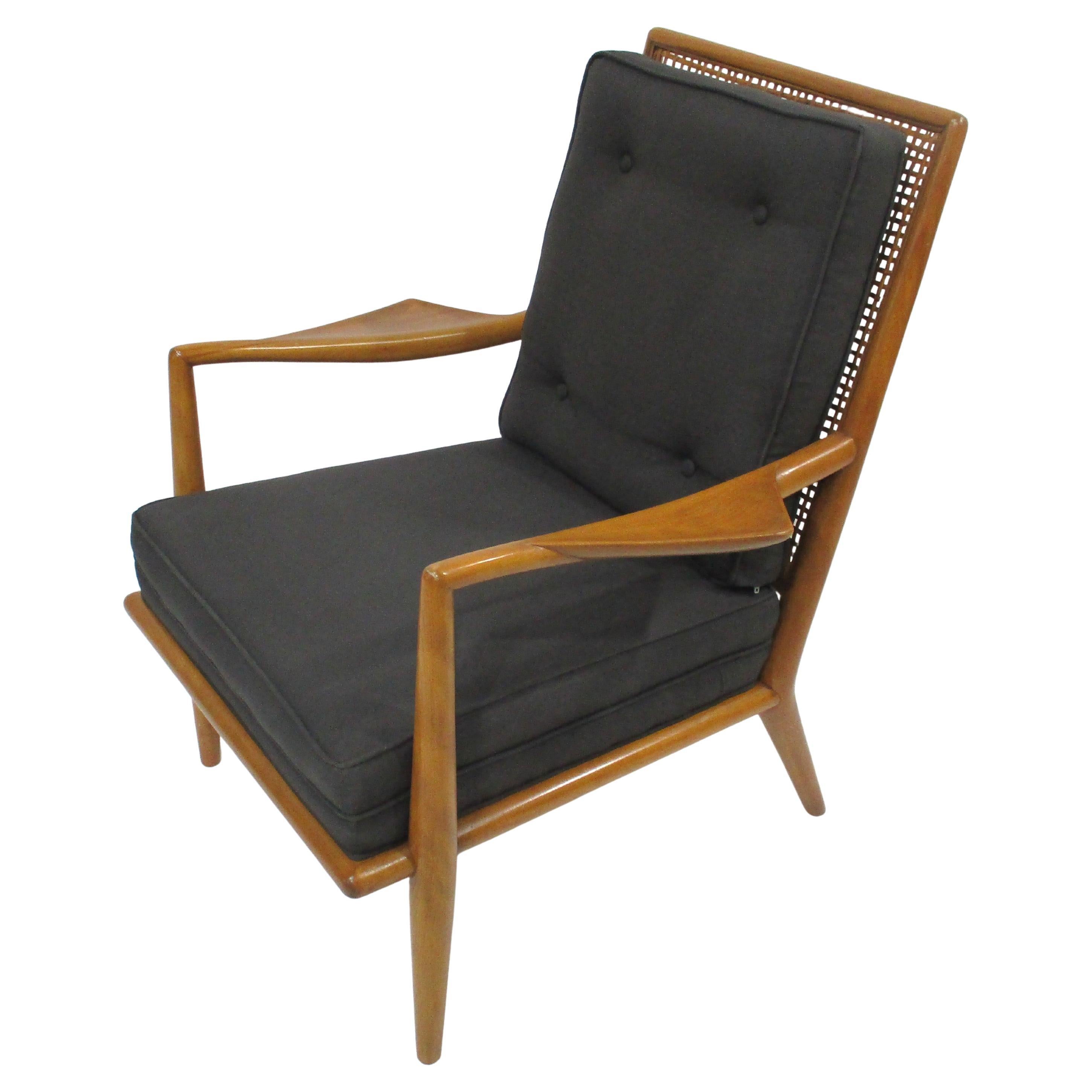 A very rare and hard to find wing lounge chair names because of the unique and stunning arm rests . This very well crafted solid mahogany framed chair has upholstered fixed charcoal toned linen styled seat and buttoned back cushions resting on a