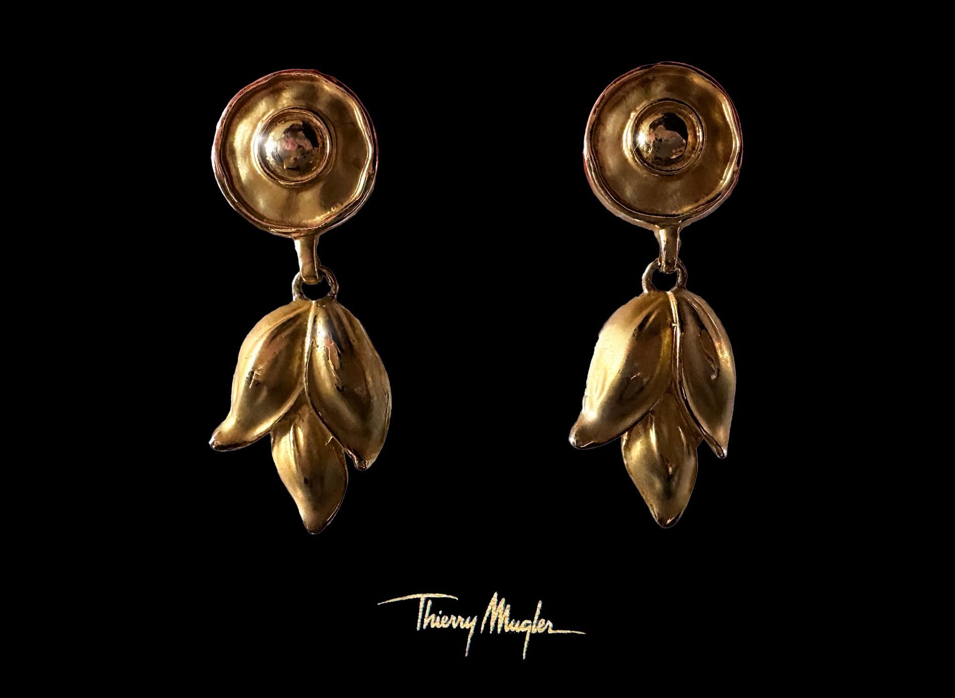 A Thierry Mugler treasure.
Extremely rare dangling clip-on earrings. A dazzling embodiment of bold sophistication and organic elegance. Featuring a sculptural gold-tone design, they capture the essence of nature reimagined through a lens of