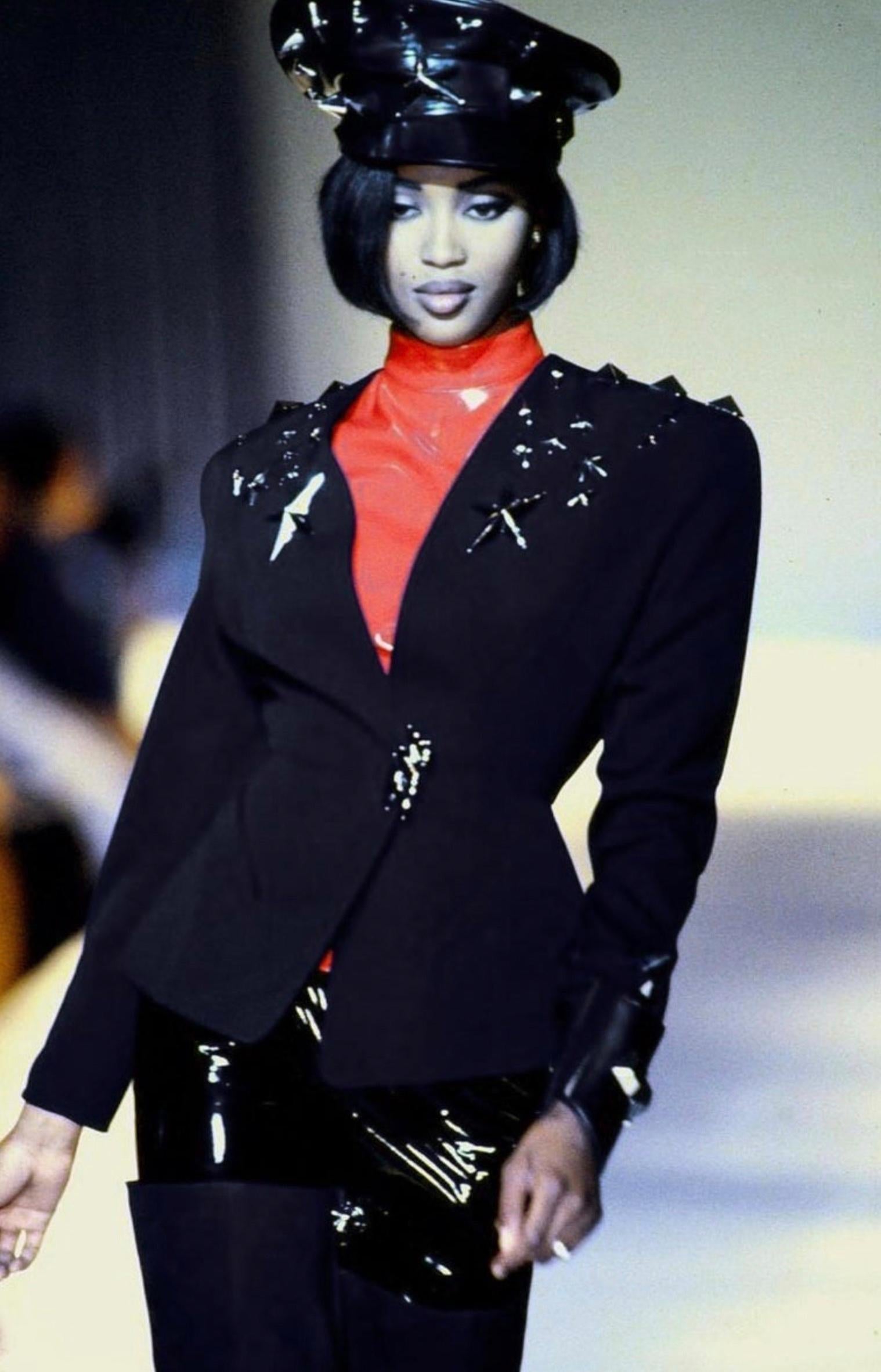 Iconic Thierry Mugler FW 1990 jacket. Similar version of this was worn by Naomi Campbell on the Runway Show.
Extremely rare Collectors piece, a true Thierry Mugler Statement jacket.

Stunning fitted black jacket with silver metal Mugler star details
