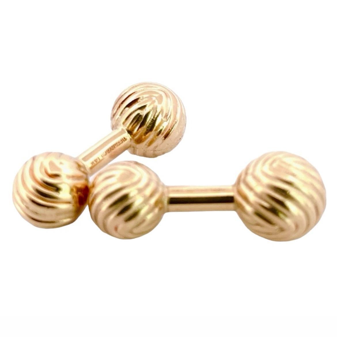 This Rare Tiffany & Co.'s 14K Yellow Gold Knots Cufflinks set is crafted with precision and sophistication, these cufflinks exude understated luxury. Featuring the iconic knot design in lustrous yellow gold, they add a touch of refinement to any