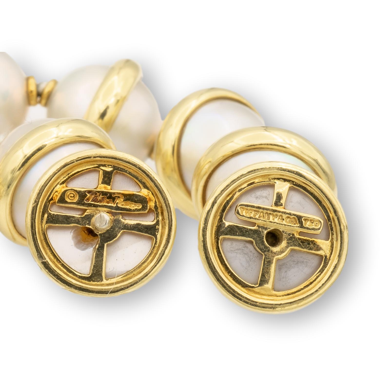 This rare and unique Tiffany & Co. necklace, designed by Paloma Picasso, is from 1981. Finely crafted in 18K yellow gold, the necklace features 25 gold bands, each connected to two Mabe pearls, measuring 12mm each (15mm with the gold rim). The