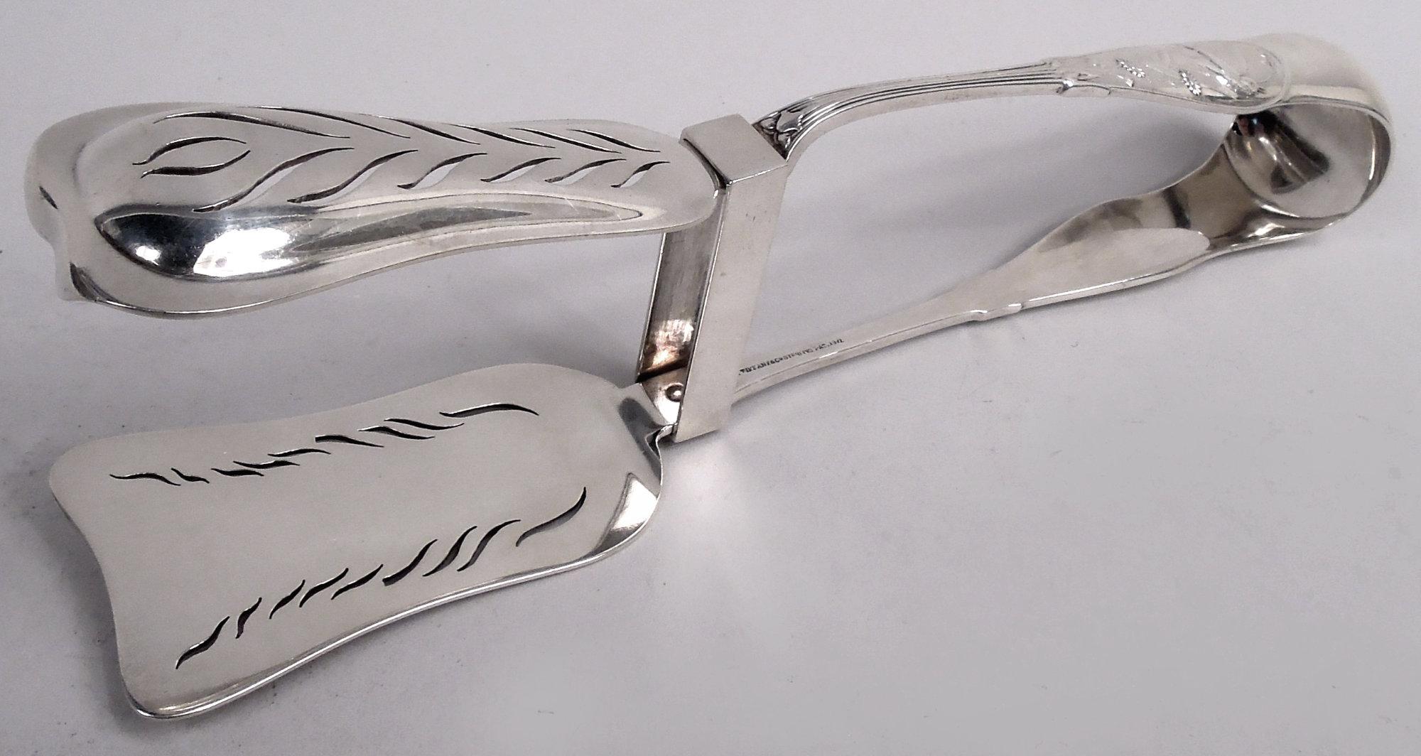 Raras pinzas japonesas para espárragos de plata de ley. Fabricado por Tiffany & Co. en Nueva York, hacia 1875. Forma en U; terminales con ornamento estilizado en bajo relieve: Pájaros posados, flores y espadañas. Monograma de escritura entrelazada