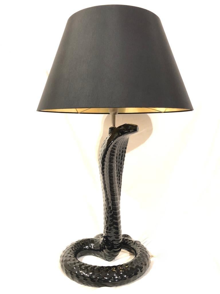 Rare Tommaso Barbi sleek black glazed ceramic majestic table lamp.

New wide black lamp shade with gold interior. 

Fully functioning lamp.

Minor sign of wear. No structural damage or chips. 

Measures: 55 cms Cobra height
38 cms Cobra