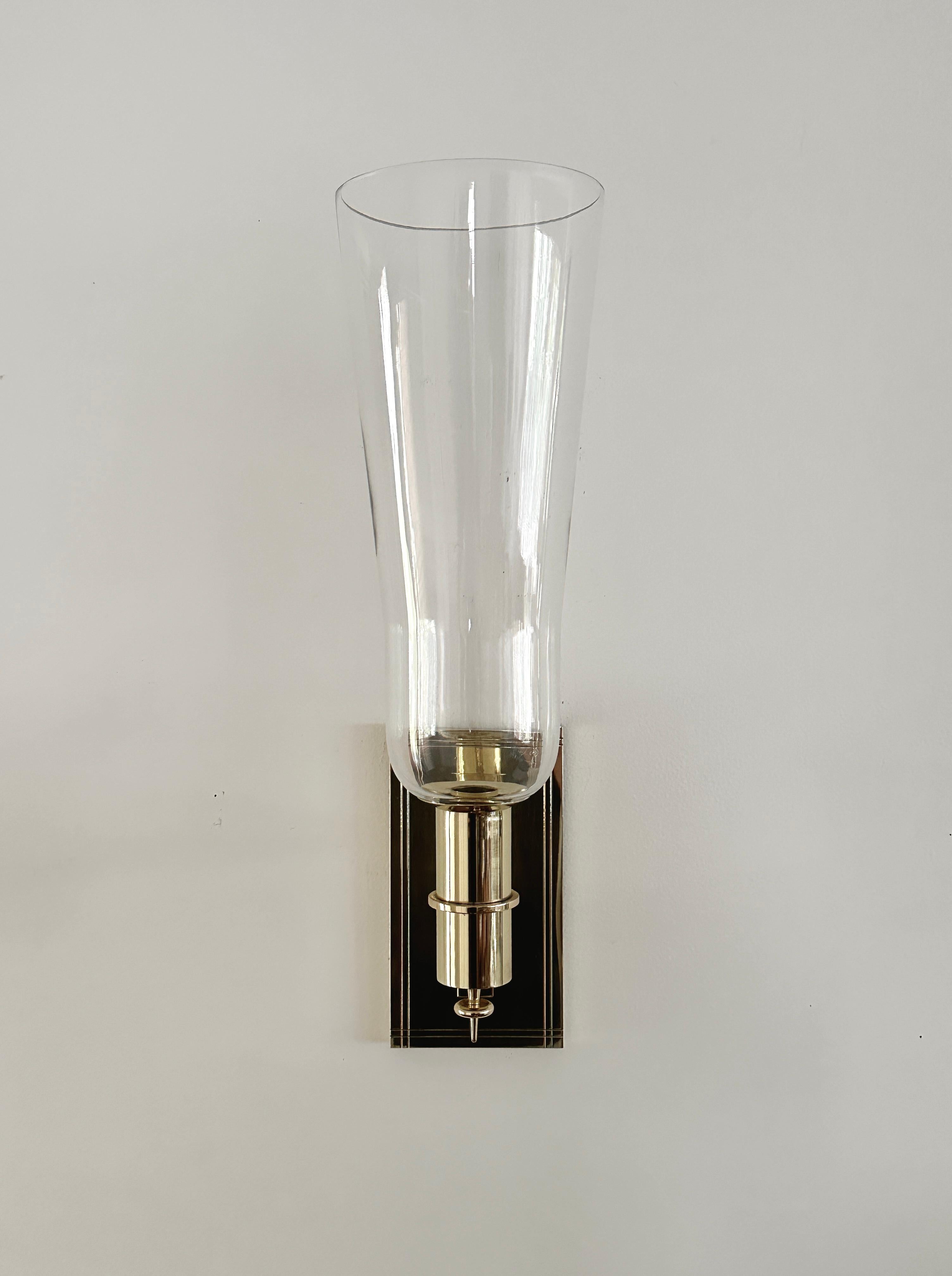 A vintage solid brass and blown glass sconce designed by Tommi Parzinger. Dorlyn Silversmiths made both mass produced and custom pieces for Tommi Parzinger. The sconce is not in the Dorlyn Silversmith catalog, yet the componenets are signature Tommi