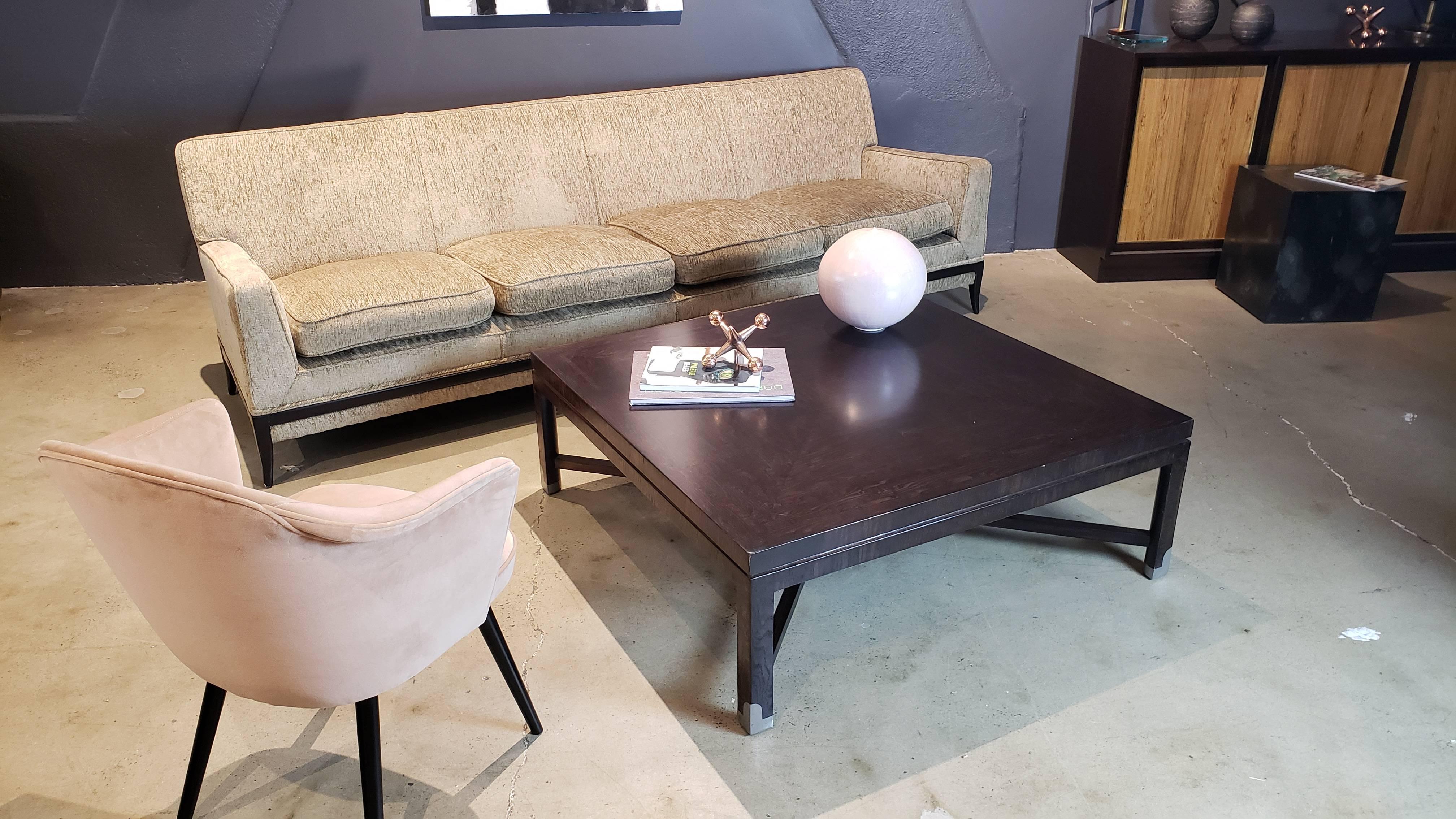 Hard to find Tommi Parzinger sofa with classic midcentury lines, circa 1950. Handsome dark walnut or mahogany decorative stretchers and elegant sabre leg make this piece at home alongside both traditional and modern pieces. Very good vintage