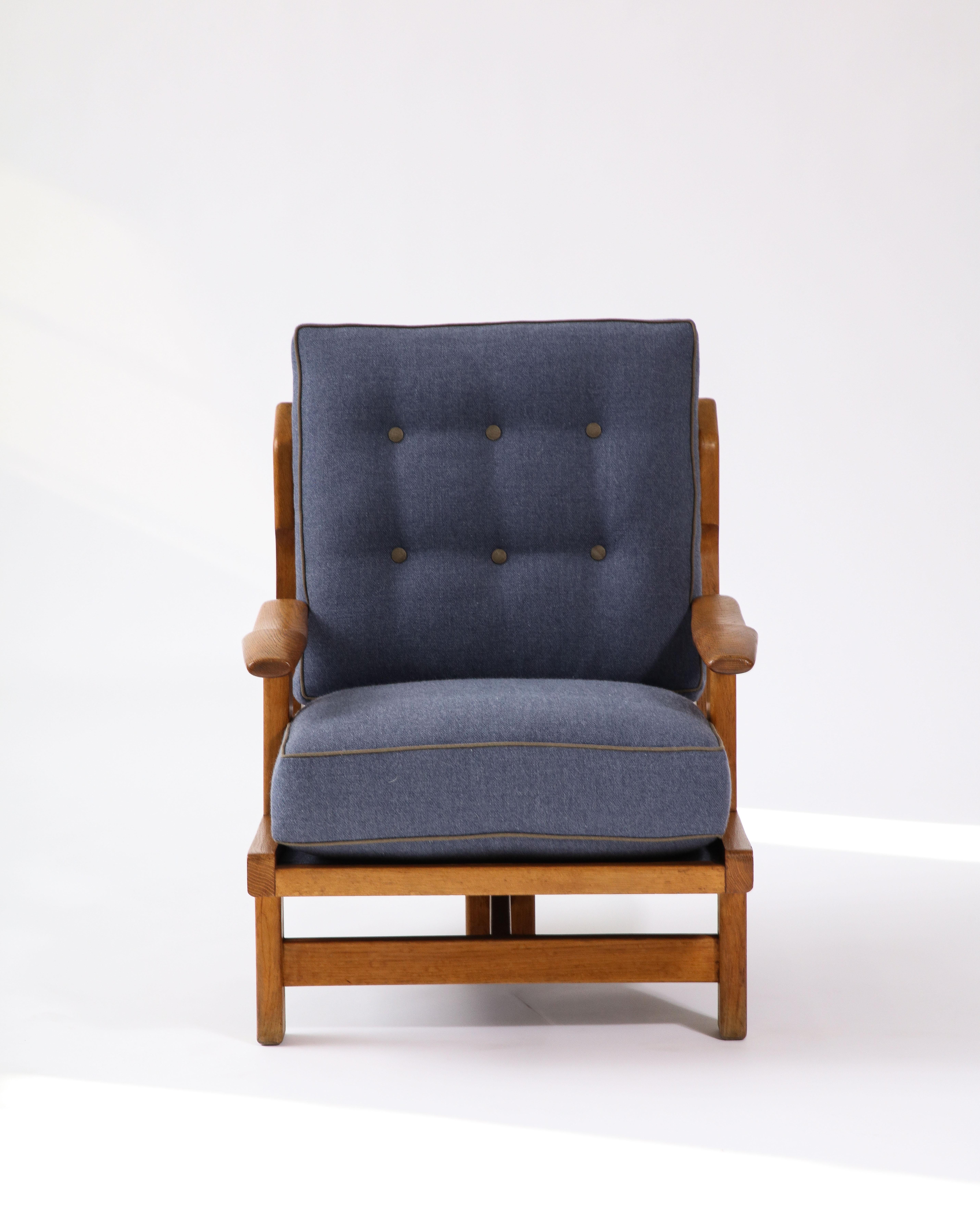 Deux disponibles ; prix individuels. 

Rare fauteuil tripode sculptural de Guillerme et Chambron. Cette chaise est incroyablement confortable, avec de nouveaux coussins tapissés de lin marine avec des passepoils et des boutons contrastés de couleur
