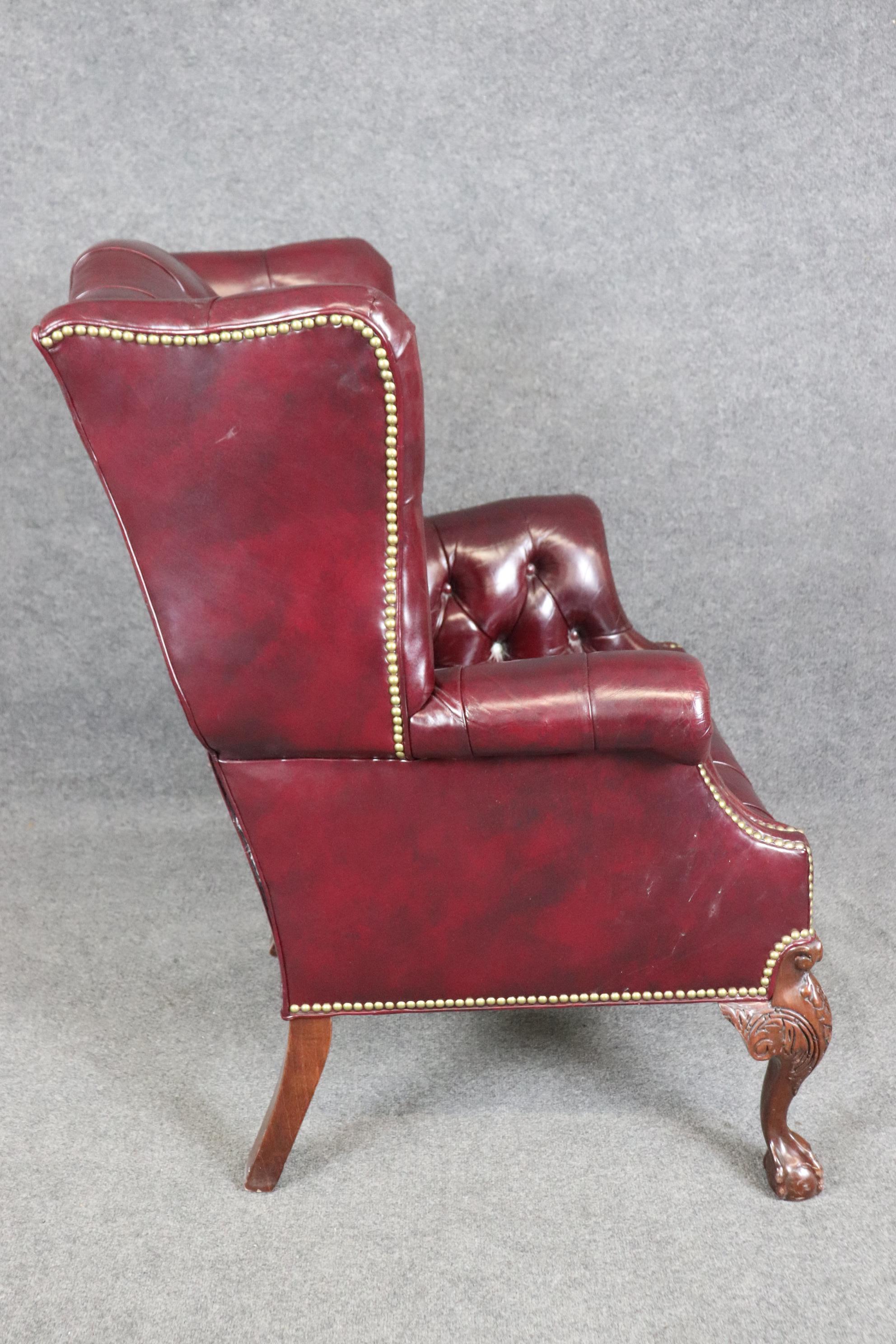 Fin du 20e siècle Rare fauteuil à oreilles Chippendale en cuir bourgogne touffeté avec boule et griffes