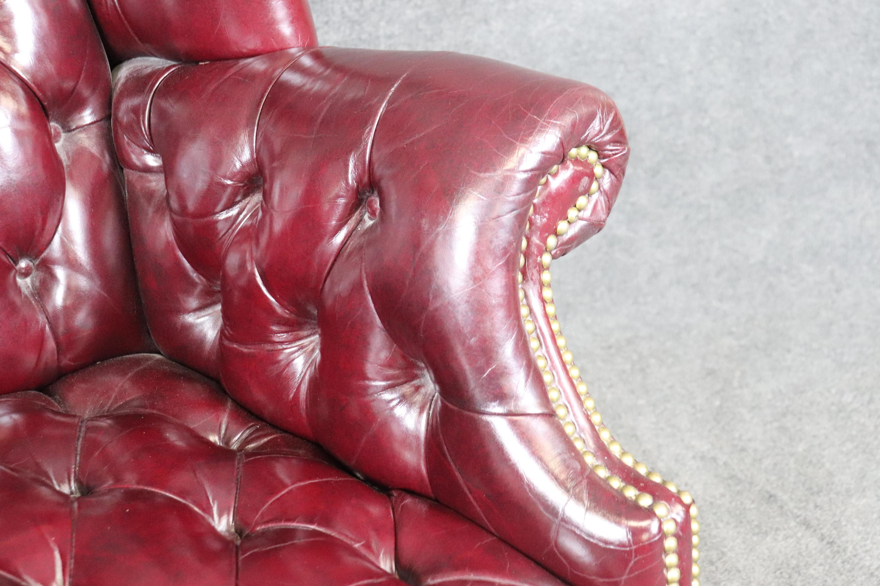 Cuir Rare fauteuil à oreilles Chippendale en cuir bourgogne touffeté avec boule et griffes