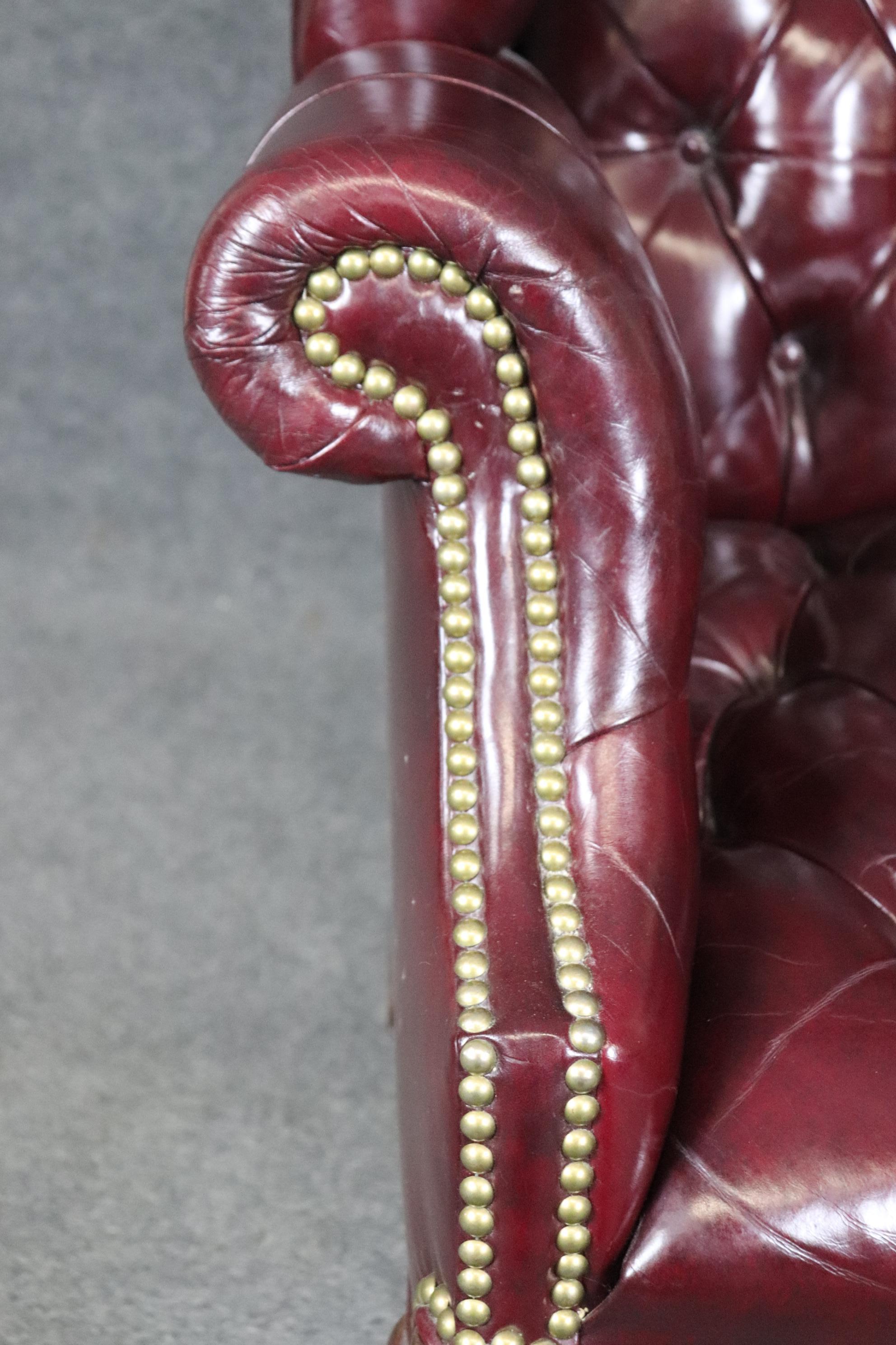 Rare fauteuil à oreilles Chippendale en cuir bourgogne touffeté avec boule et griffes 1