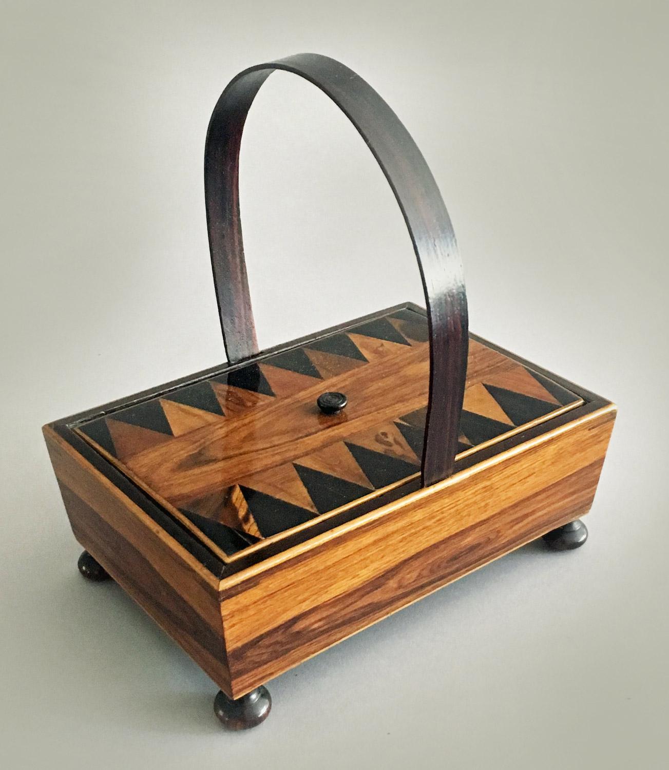 A rare early 19th century Tunbridgeware rosewood sewing box with hoop handle, the lid with tiny carved knob is decorated in the striking Van Dyke pattern, the sides in bold rosewood veneers, mounted on turned turnip shaped feet. When the lid is