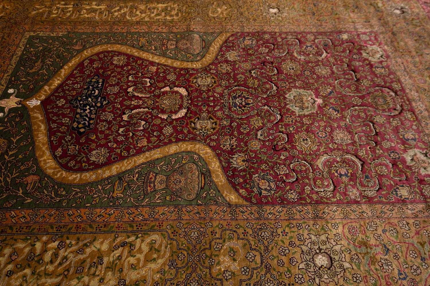 Dies ist ein Kum-Kapi-Gebetsteppich aus Seide und Metallfäden. Es zeigt ein von Zareh Penyamin gewebtes Kopfmotiv und trägt seine kalligraphische Signatur im Metallfaden am Fuß der zentralen Palmette. Zareh gilt bis heute als der führende
