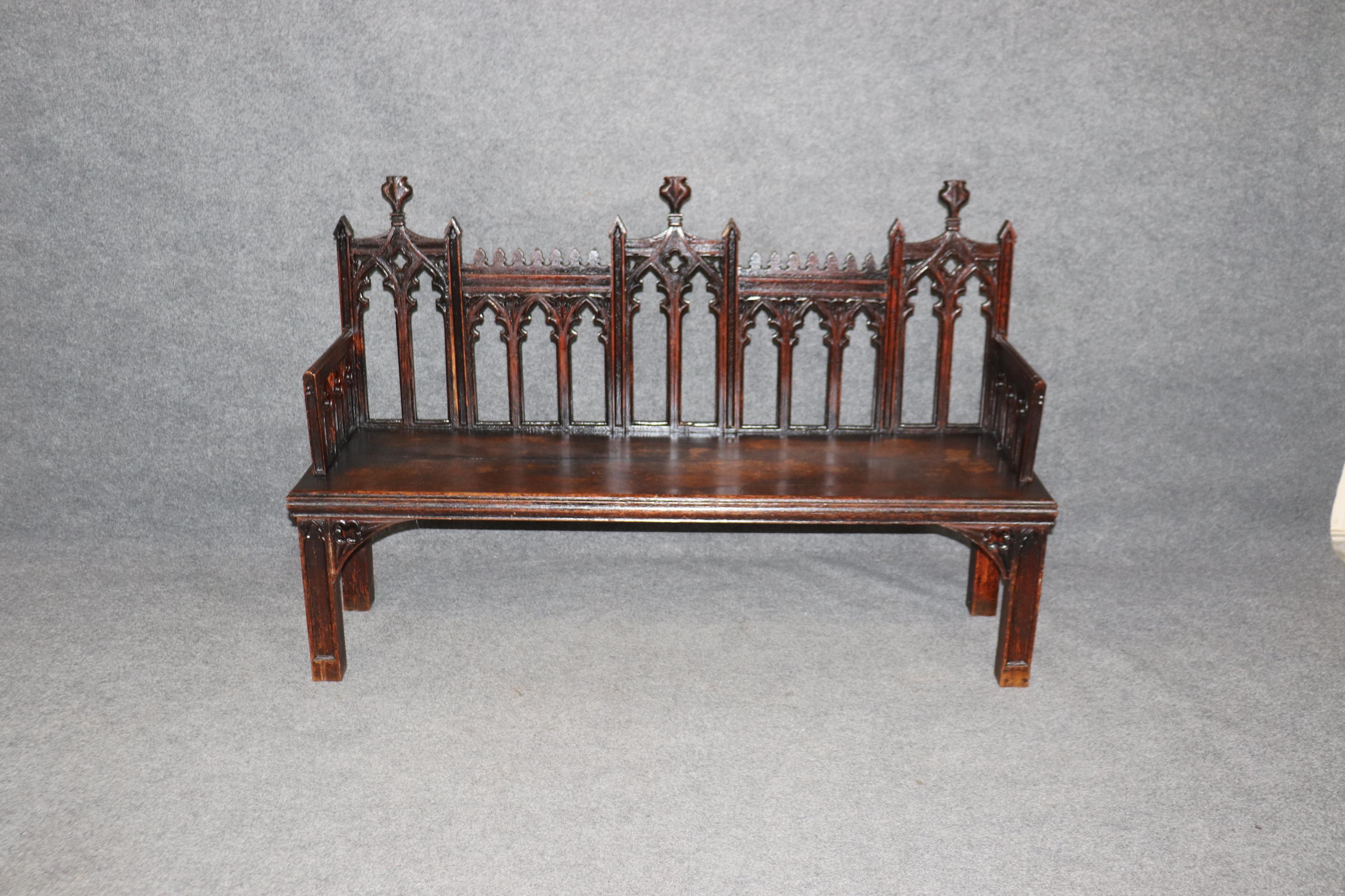 This is a superb and very unique form of Gothic bench from England. The bench features a dark oak finish with minor signs of age and use such as finish losses and minor wear. The bench would look stunning with a bright contrasting cushion of some