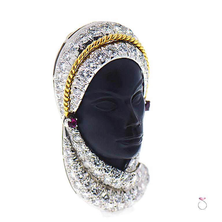 This veiled lady brooch is superbly crafted in platinum and 18K yellow gold, with approximately 4.60 ct micro pave round diamonds on her veil. She has ruby earrings totaling approximately 0.10 ct. Her face is carved in Ebony with stunning details