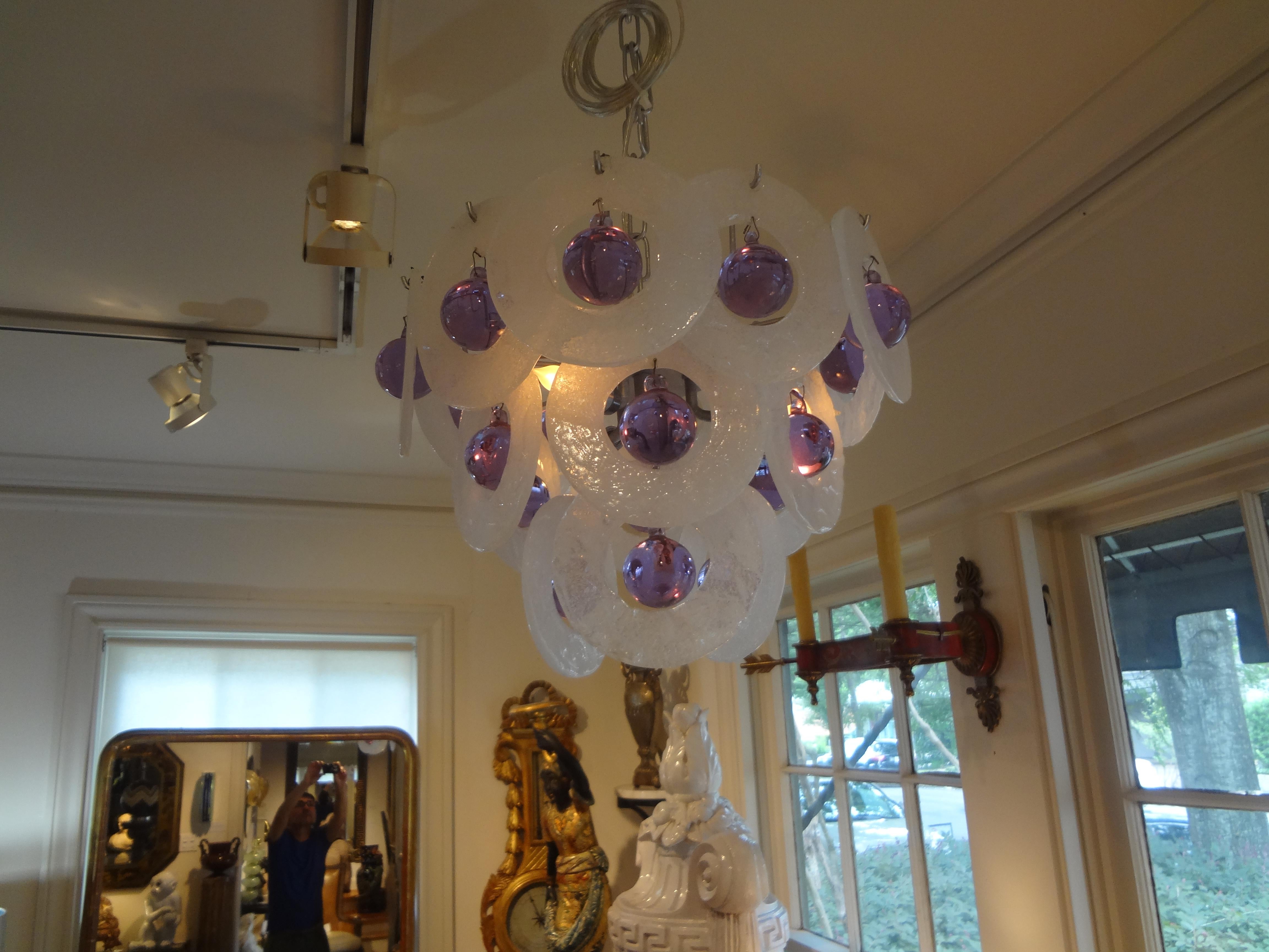 A rare midcentury Venini style Murano glass pendant chandelier possibly by Toni Zuccheri featuring multiple white glass open discs with purple spheres hanging from each. This highly unusual Murano glass chandelier or lantern has been newly wired for