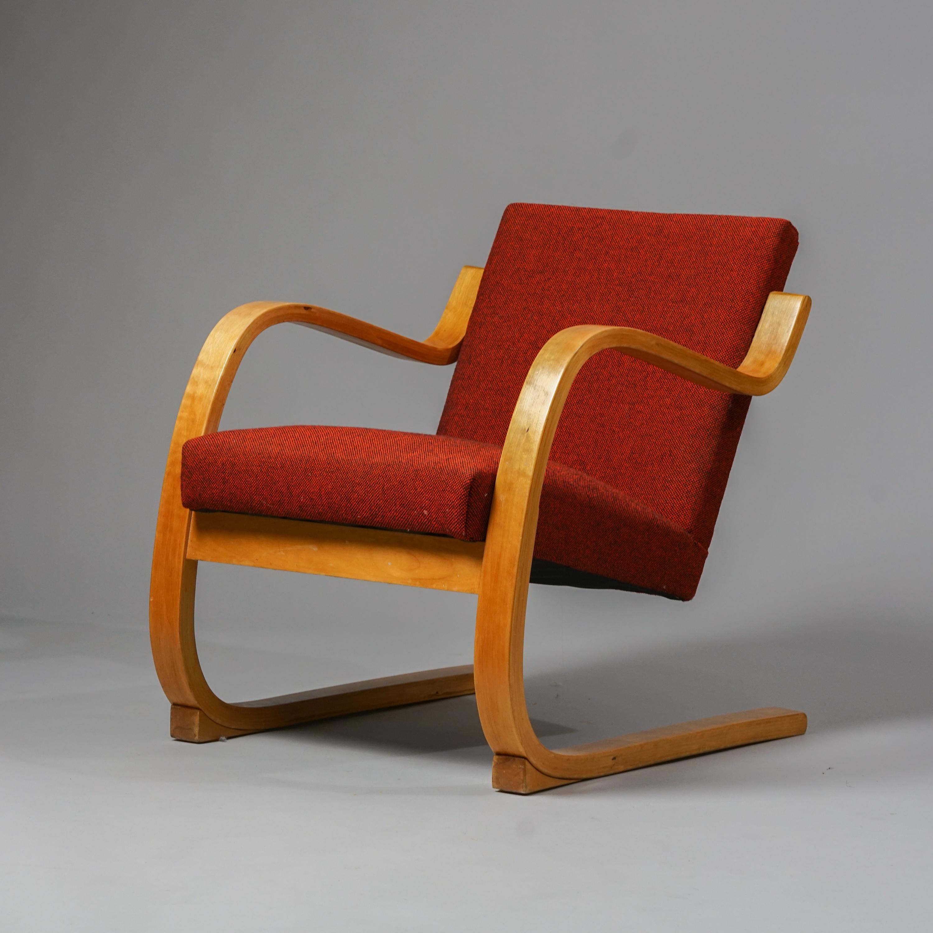 Rare fauteuil modèle 402 d'Alvar Aalto pour Artek des années 1950 avec des cales sur les pieds. Pieds en bouleau laqué, revêtement en tissu de laine rouge. Bon état vintage, usure mineure correspondant à l'âge et à l'utilisation. Belle patine sur