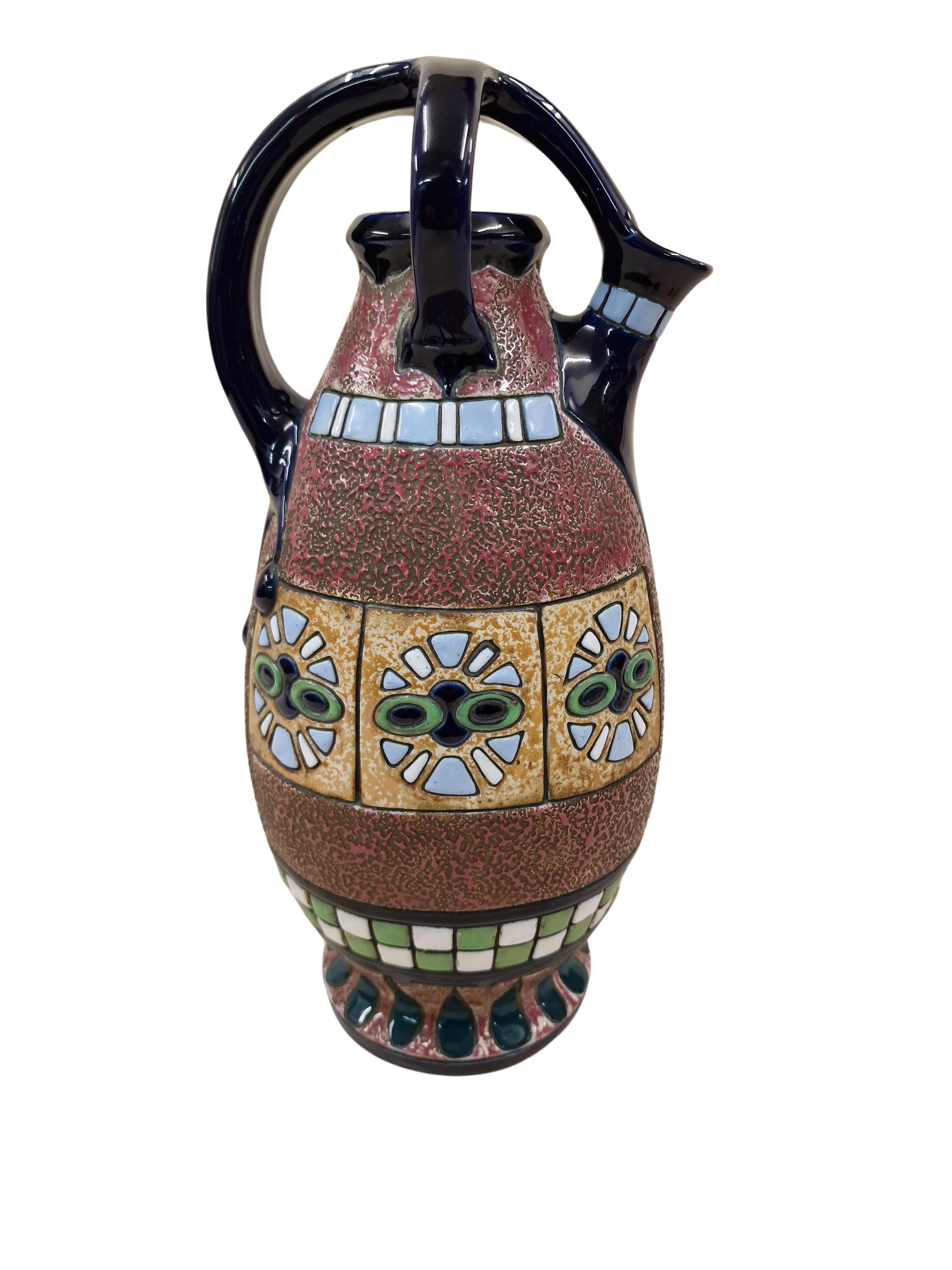 Very impressive jug from the Art Deco period, made around 1915 by the Amphora company from the Czech Republic.

The object can be viewed from several sides. On the main display page you can see an impressively designed horse-drawn carriage including