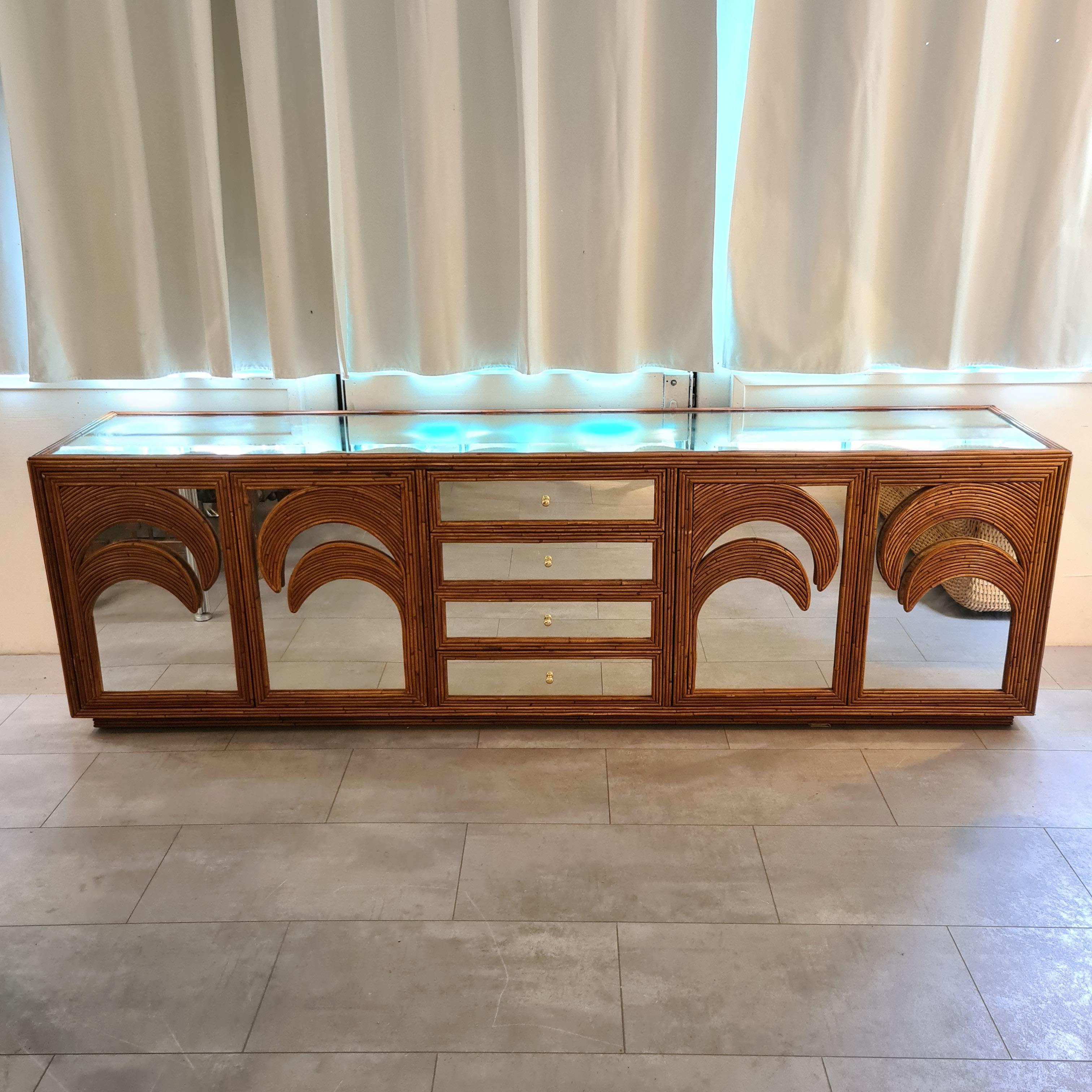 Rare beautiful large rattan and mirrored sideboard. 4 drawers, 4 doors and 2 shelves. . Simple and chic with its palmtrees patterns. Very decorative and in good condition.