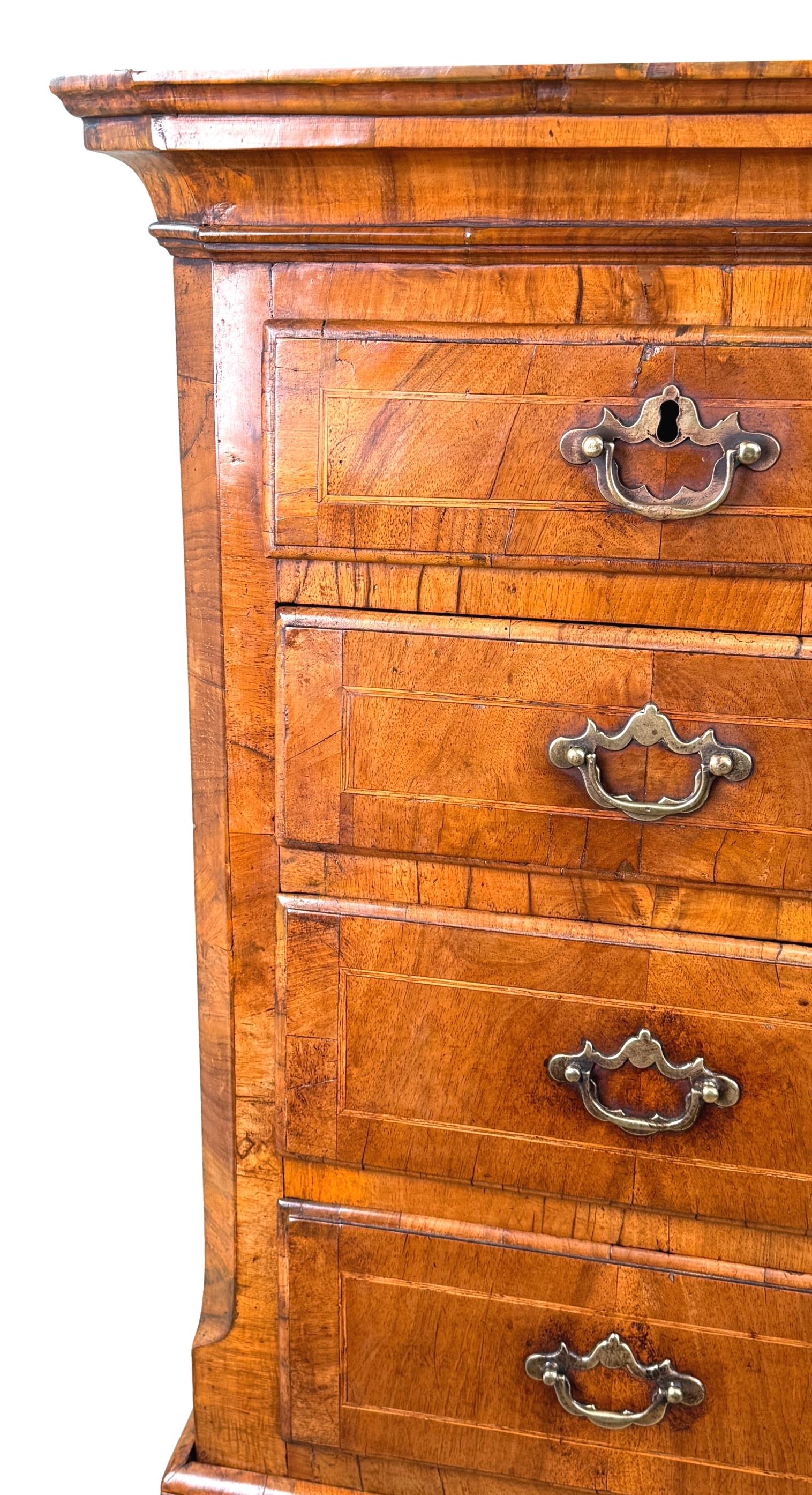 An Extremely Attractive And Very Rare Early 18th Century, George I Period, Walnut Tallboy, Or Chest On Chest, Having Superbly Figured Veneers Throughout, The Top With Two Short And Three Long Drawers, Flanked By Elegant Canted Corners To Top, Over