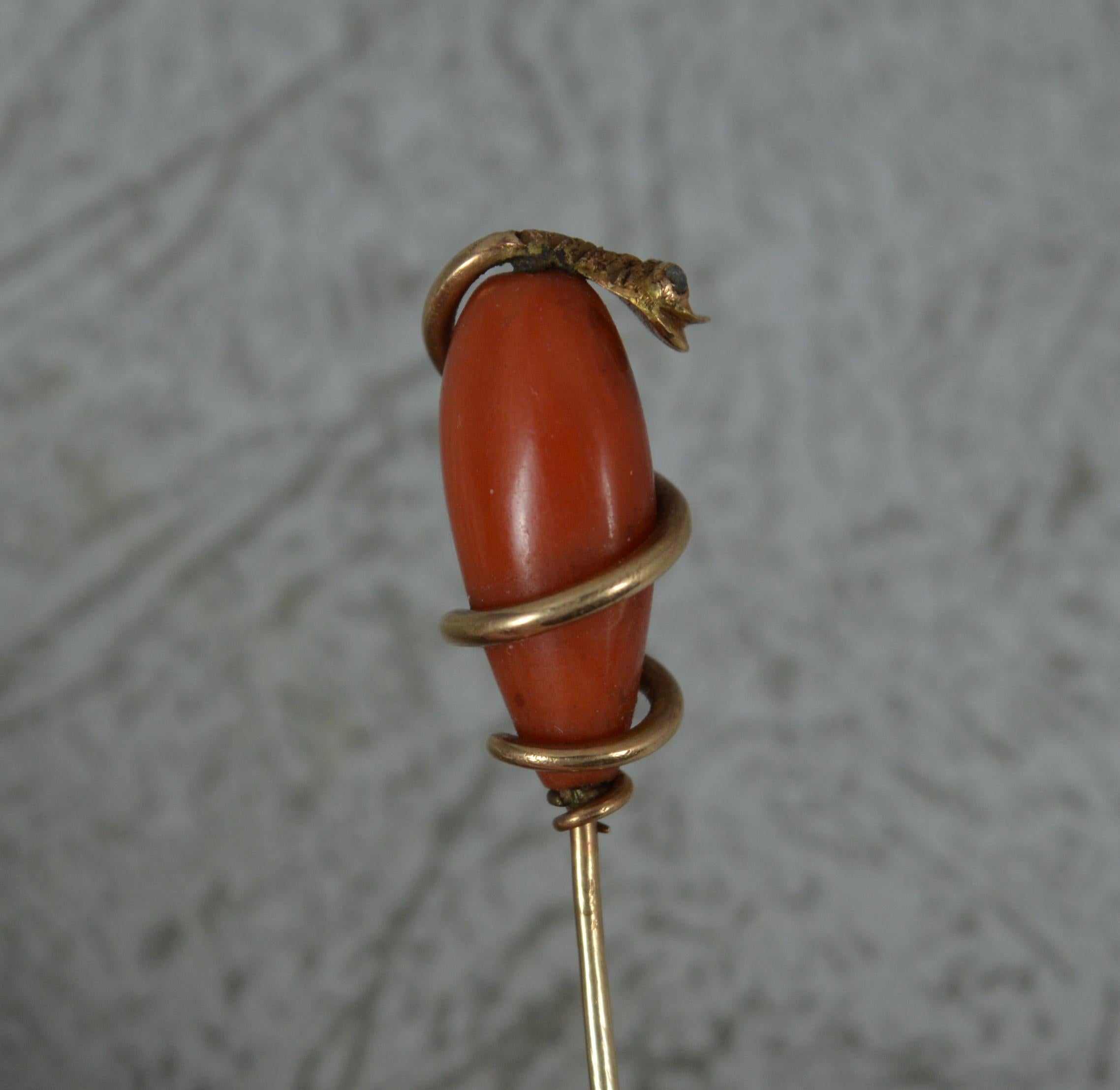 A superb mid Victorian period stick tie pin.
Designed with an entwined gold snake in 15 carat rose gold.
The snake head set with two rose cut diamond chips for eyes surrounding a single piece of natural coral.

CONDITION ; Good for age. Crisp