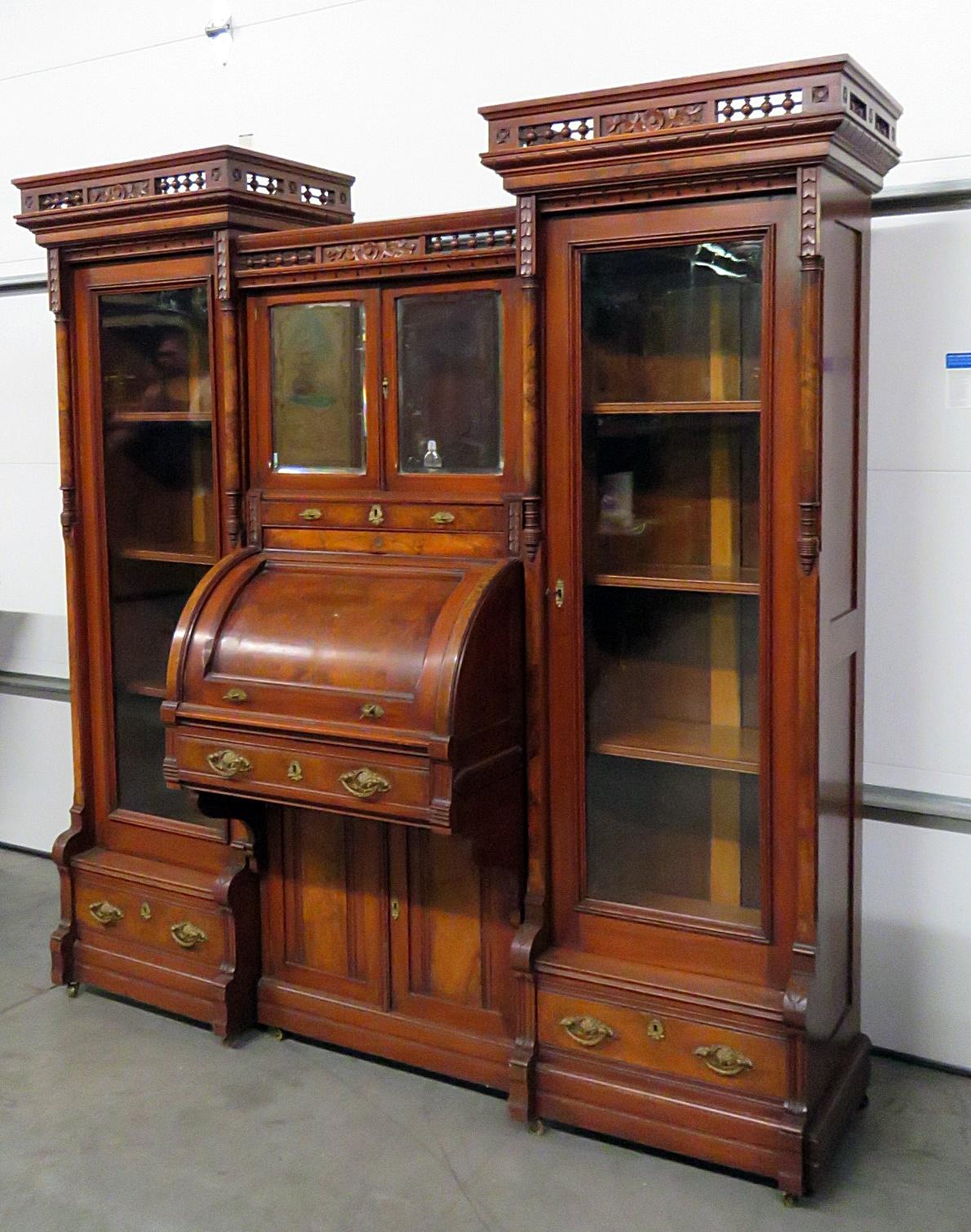 Rare Victorian 3-piece cylinder desk on casters. The side bookcases each have 1 door with 3 shelves over 1 drawer. The center has 4 doors, 1 drawer and secretary desk.