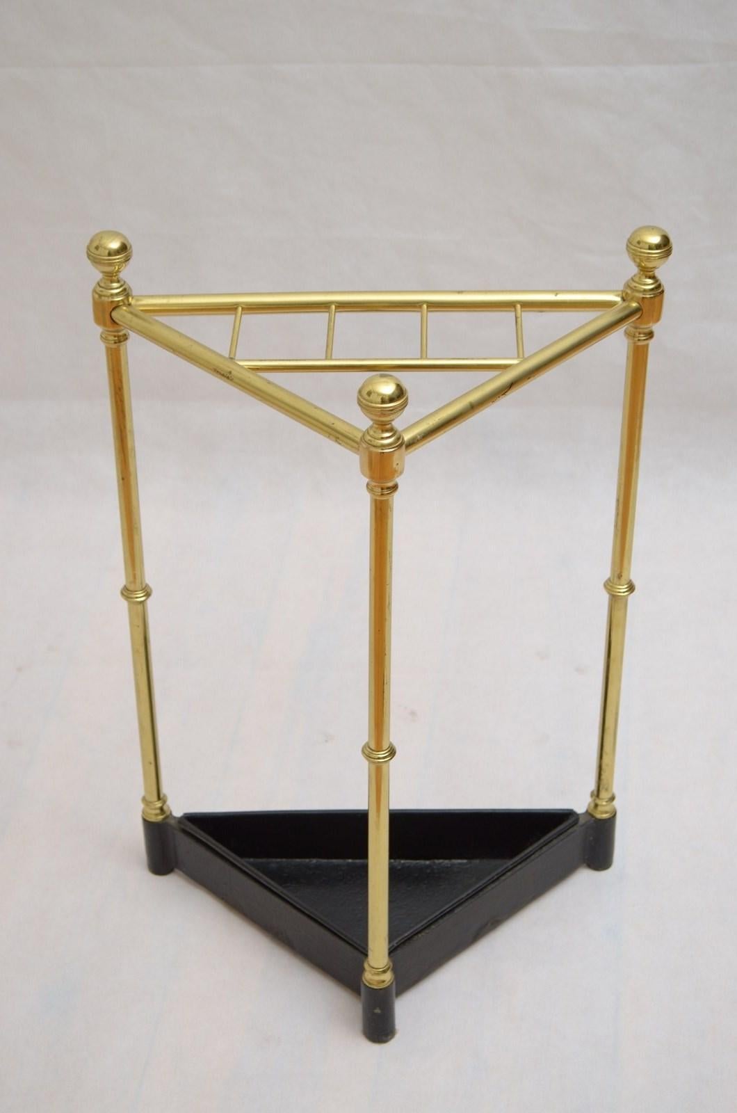 P0285 Rare Victorian corner umbrella stand or walking stick stand in brass, having six compartment flanked by decorative reeded finials stamp with registration mark, raised on three ringed uprights terminating in cast iron base with removable drip