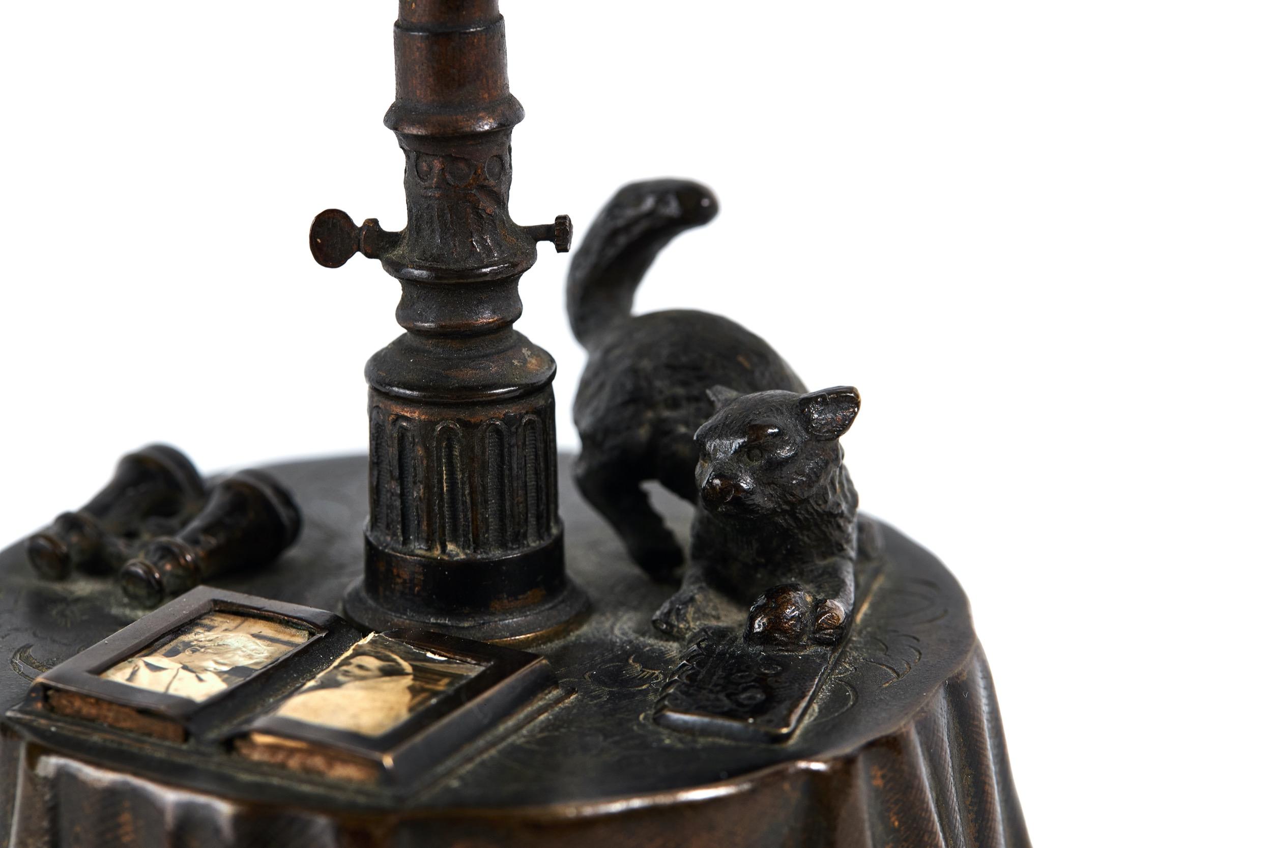 Rare Victorian Gilt Bronze Table Bell. 
In the Form of a Circular dining table.
The Etched Table cloth decorated with flowers,
And frill detail at the bottom of the table cloth. 
Applied on top with a cat, Photoframes and Binoculars
The Centre with