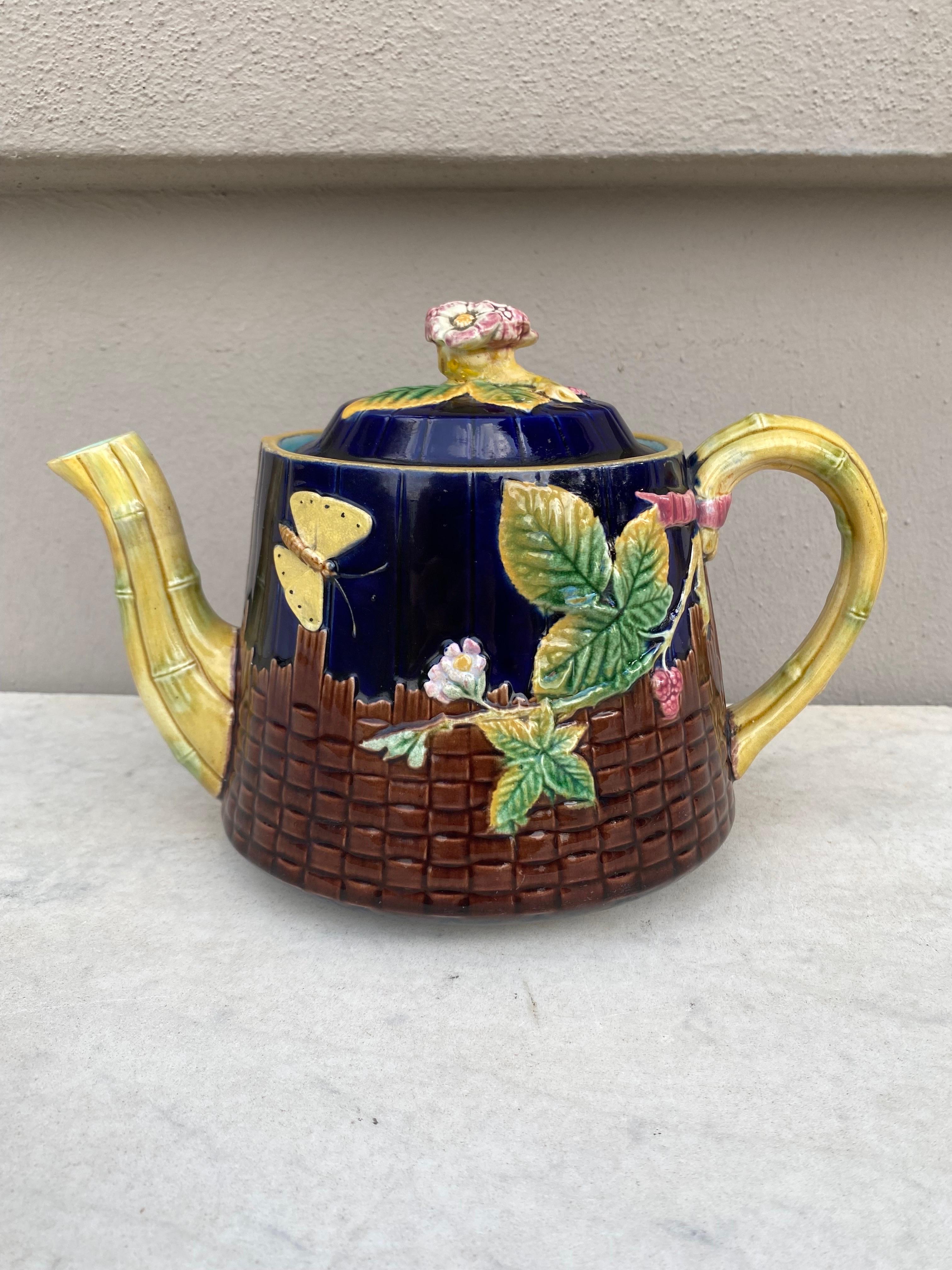 Rare Victorian Majolica Teapot signed Brown-Westhead, Moore & Co. 
Decorated with a butterfly, berries on a brown basketweave , and bamboo.
Flowers on the lid.
A very delicate lovely example of Victorian Majolica.
